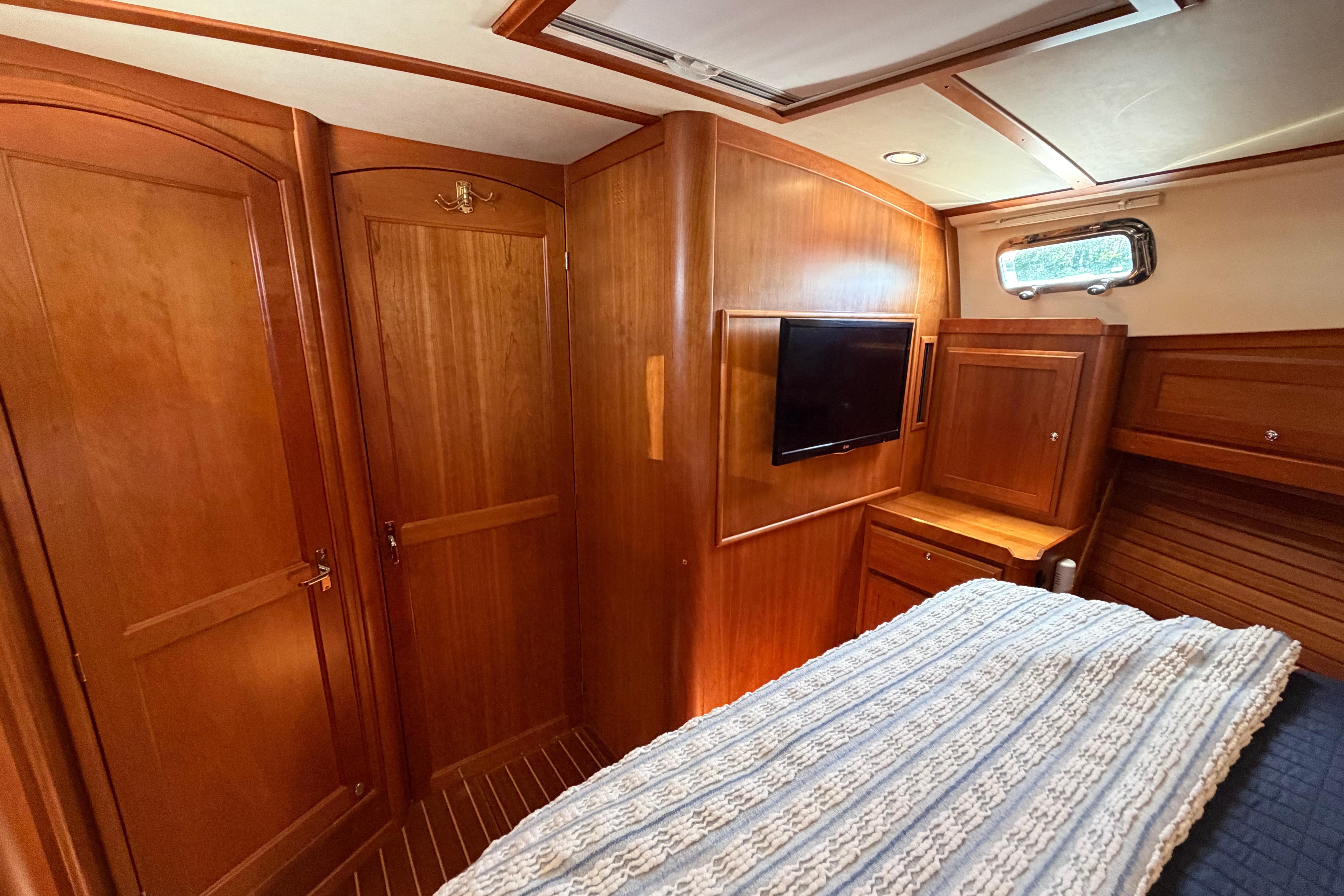 2015 Sabre 38 Salon Express cabin with wood interior, bed, and mounted TV.