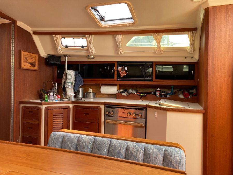 Interior of the 1990 Catalina 42 Tricabin featuring a kitchen and seating area.