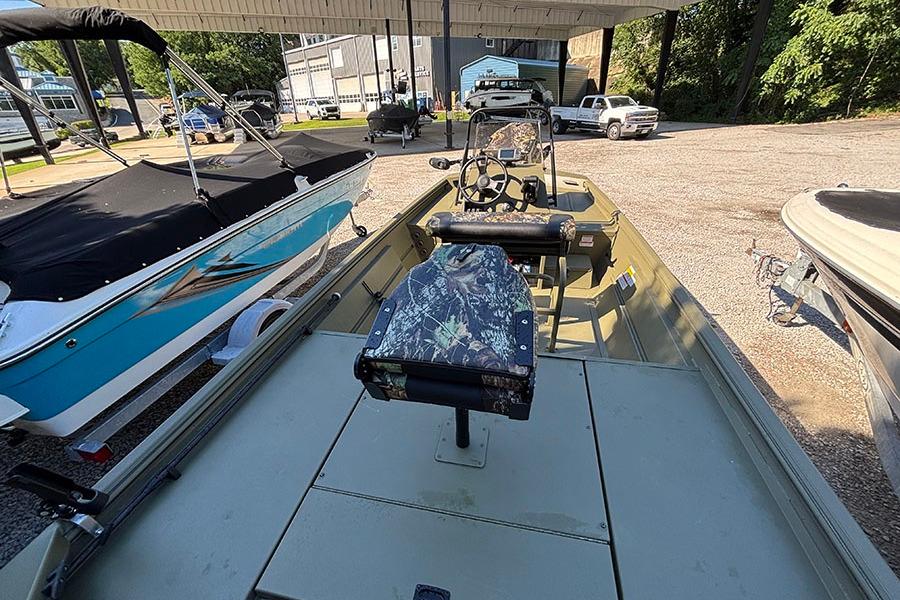 2022 Lowe Roughneck 1660 boat with camouflage seat, parked outdoors.