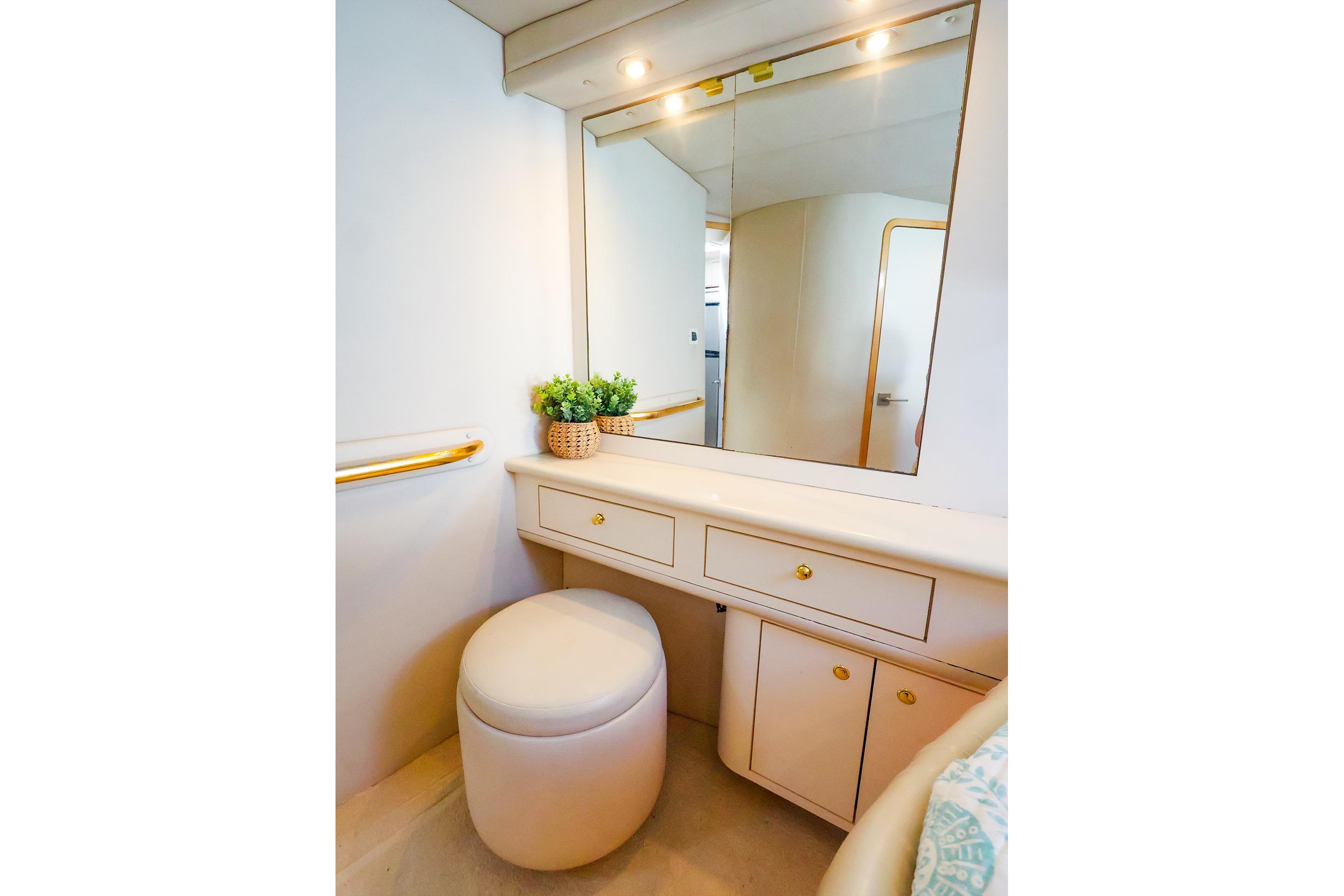 Luxurious vanity area on 1998 Sea Ray 500 Sundancer yacht with mirror and stool.