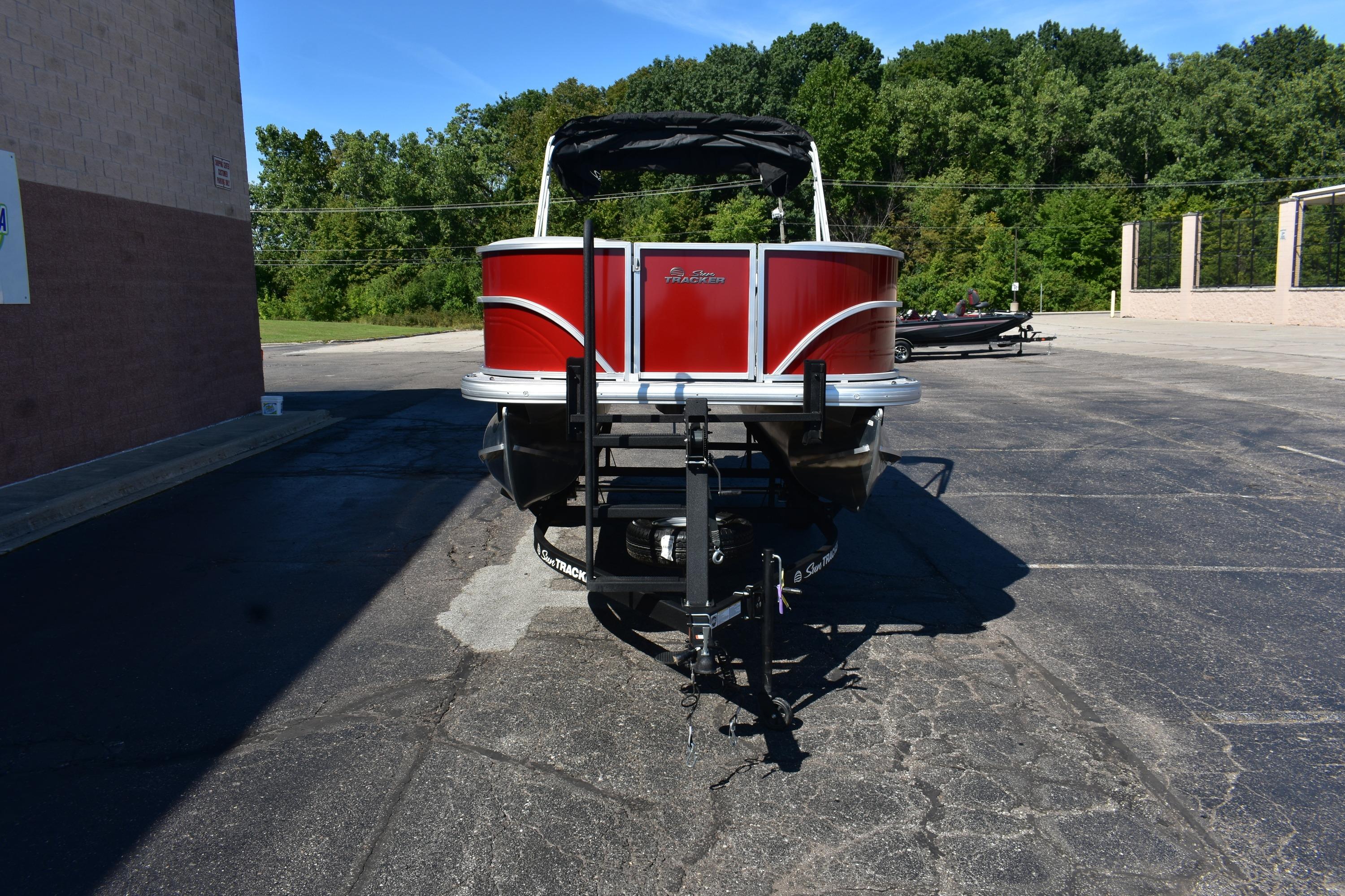 2026 Sun Tracker Party Barge 18 DLX pontoon boat in parking lot.