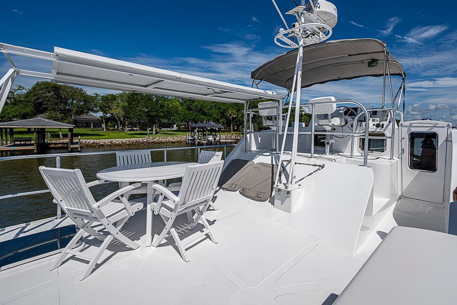 2003 Magna Marine Nova Scotia 47 yacht deck with seating and helm under blue sky.