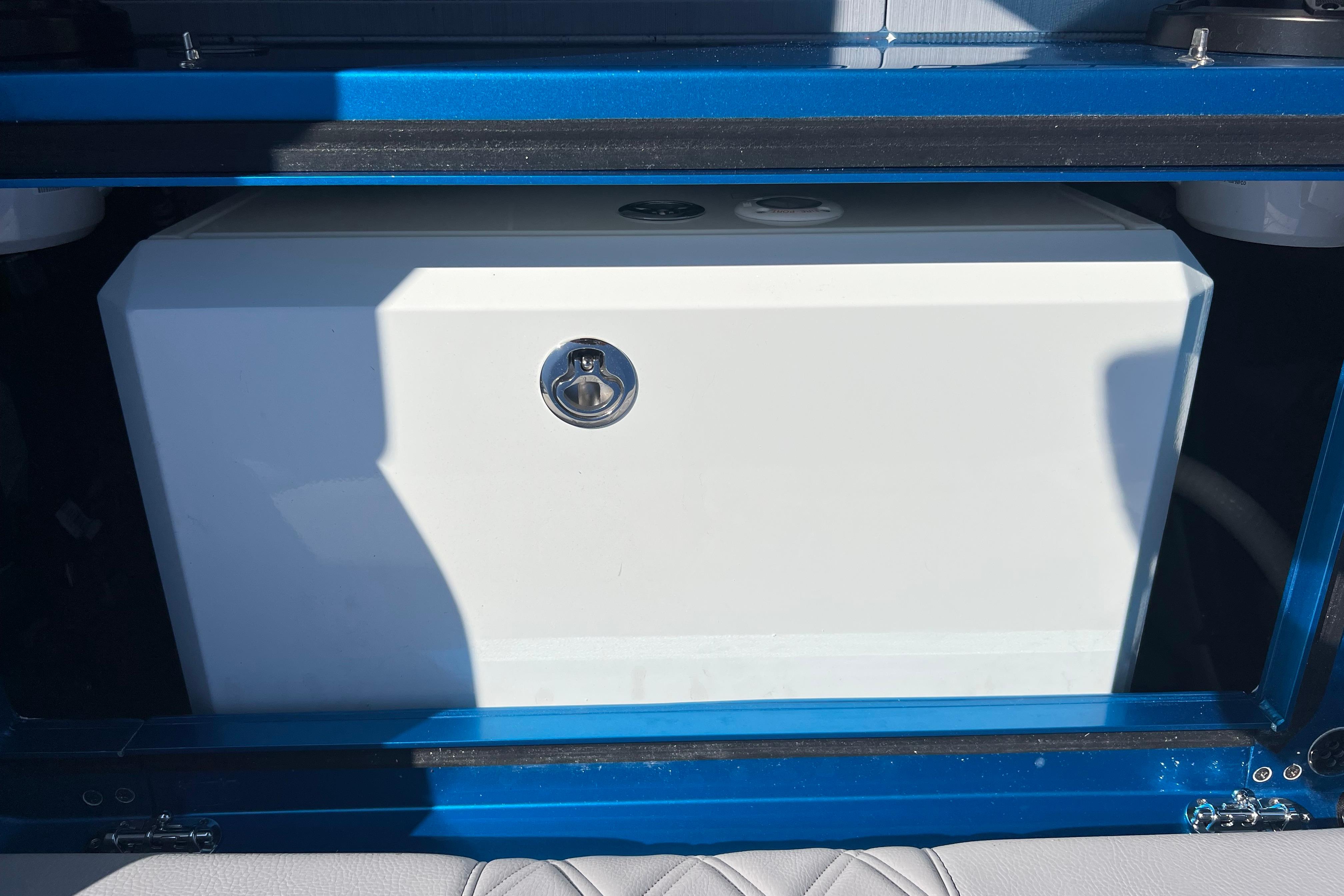 2026 Nor-Tech 450 Sport boat storage compartment with blue trim and secure latch.