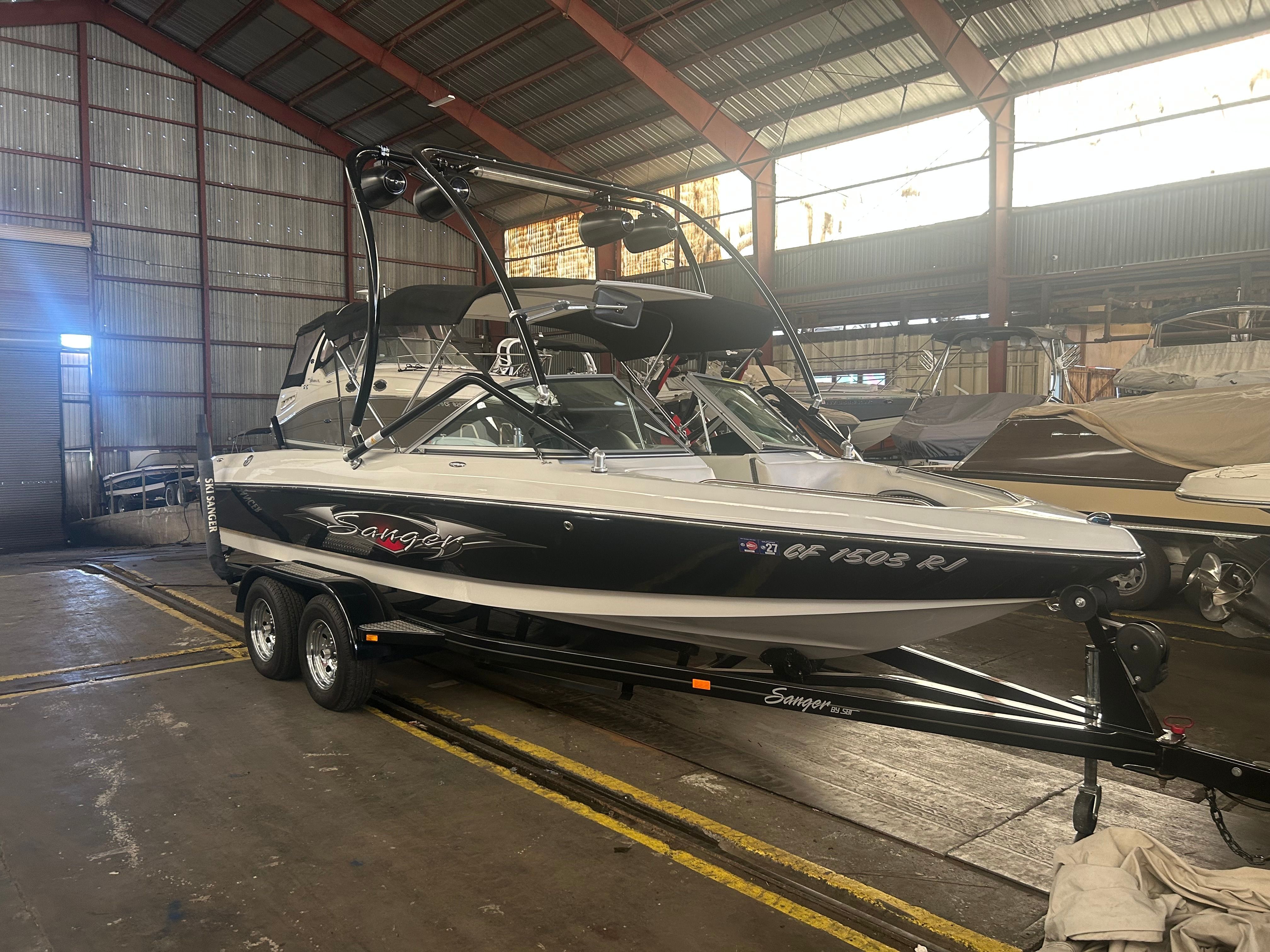A 2007 Sanger boat is on a trailer inside a warehouse.