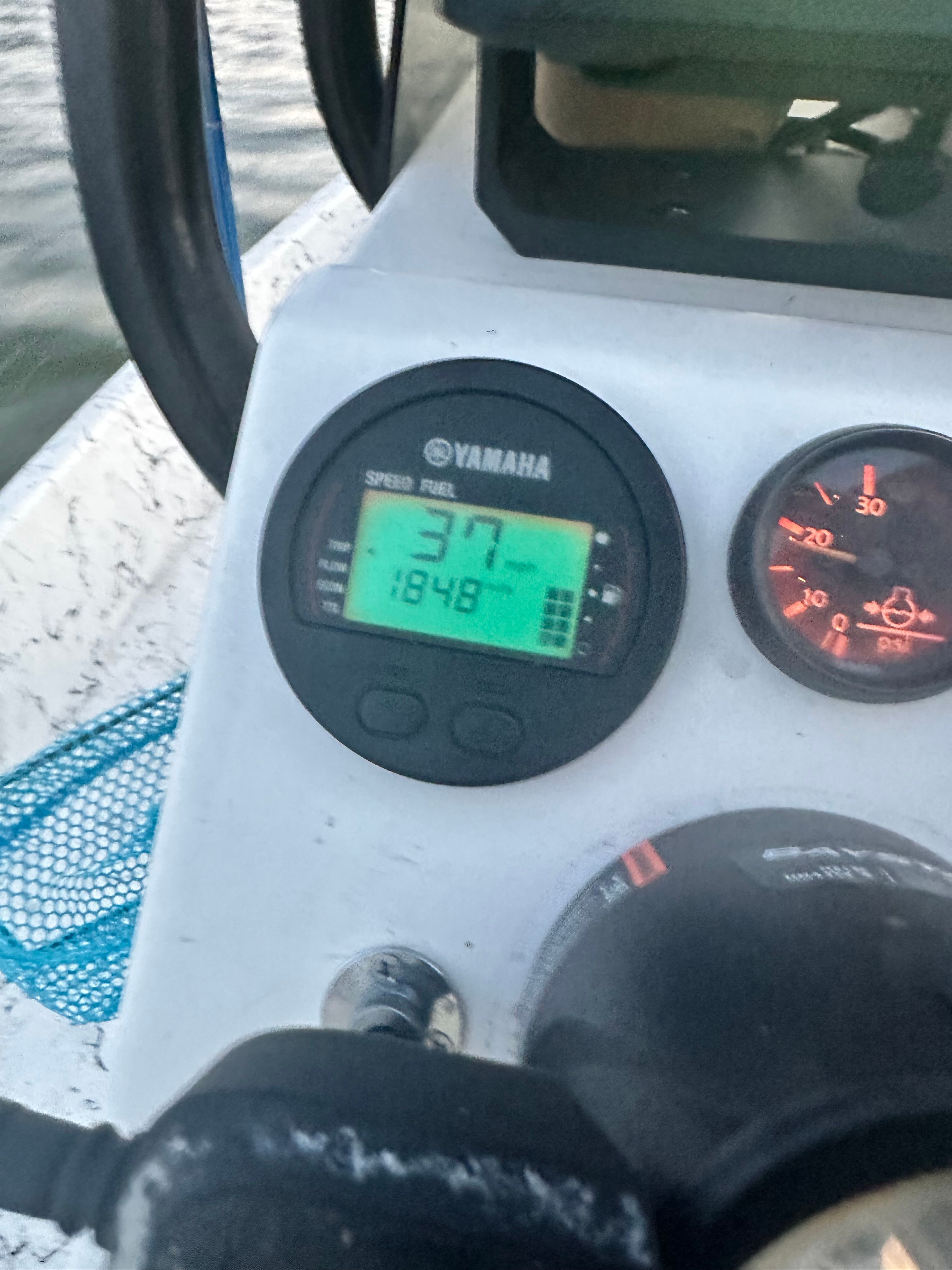 Close-up of a boat dashboard with Yamaha speedometer and other instruments.
