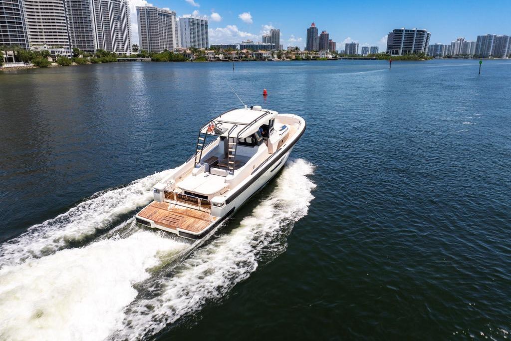 2021 Bluegame BG 42 yacht cruising in a scenic urban waterfront setting.