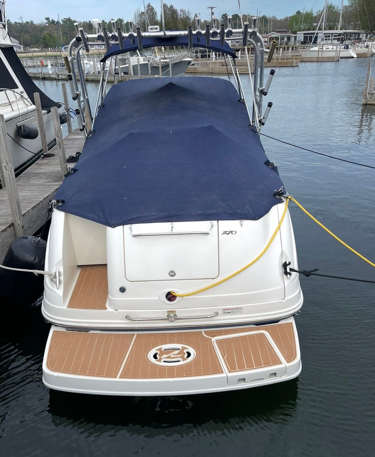 2006 Sea Ray 270 Amberjack boat docked with cover.