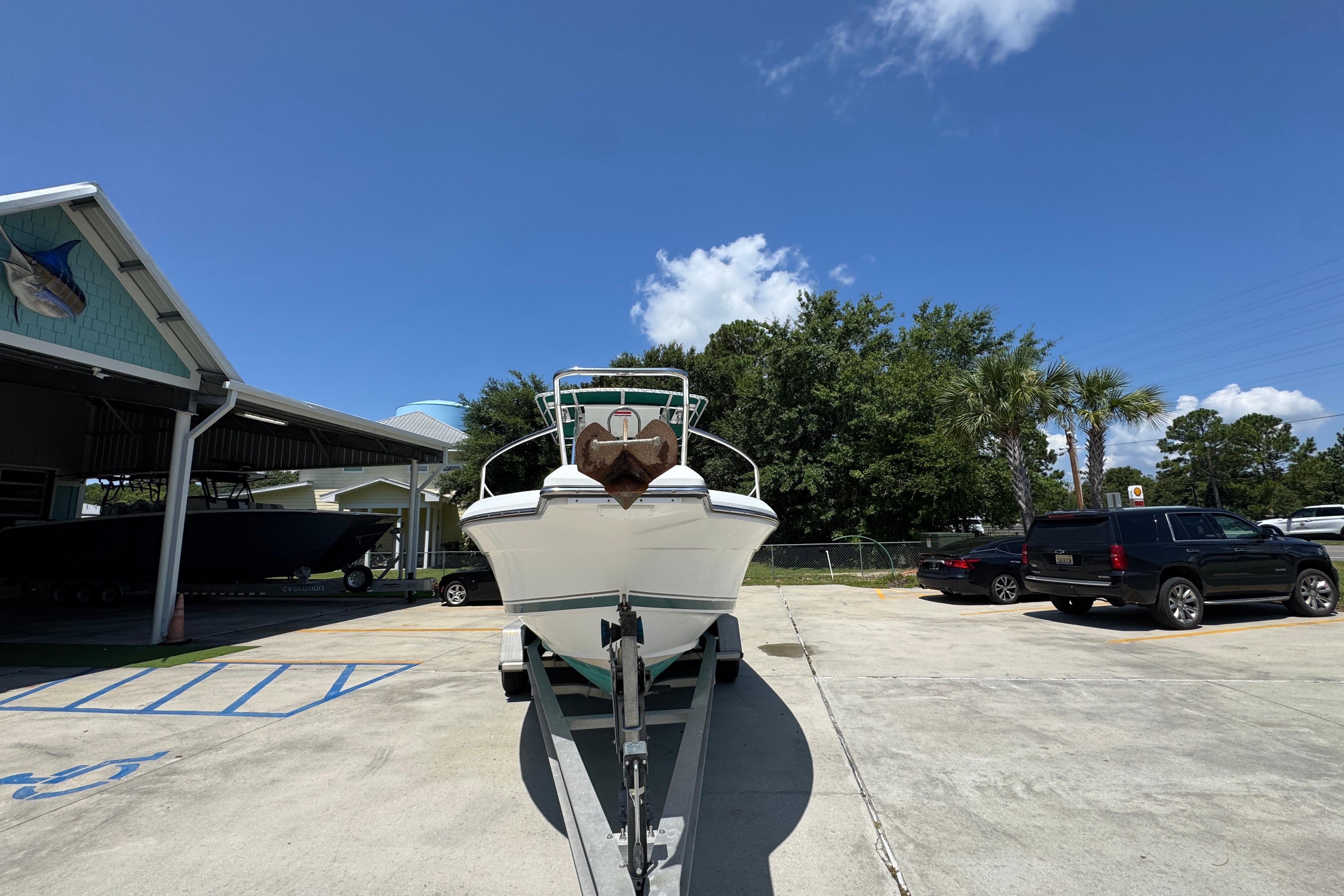 2000 Stamas 250 Tarpon boat on trailer in sunny parking lot.