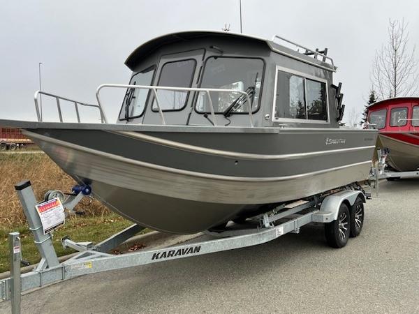 2024 Spartan 220 Maximus boat on Karavan trailer, parked outdoors.