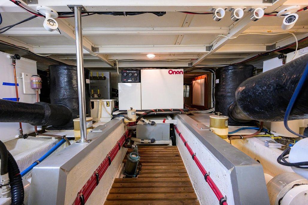 Engine room of 1999 Grand Banks 42 Europa yacht with Onan generator and mechanical systems.