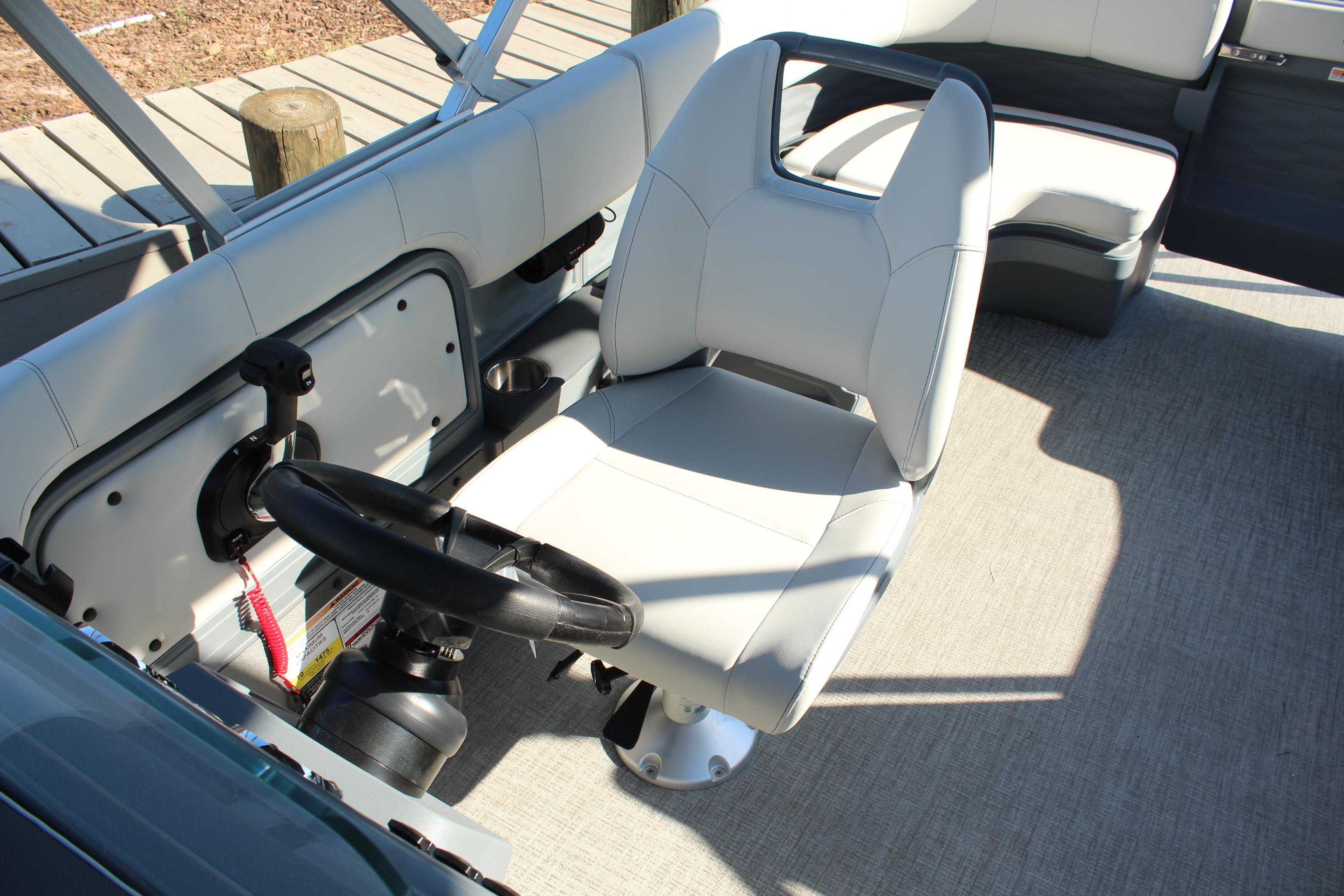2026 Tahoe Pontoon Aura boat interior with steering wheel and comfortable seating.