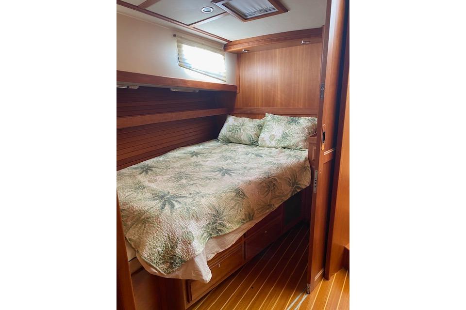 Cozy cabin interior of 2010 Sabre 38 Express with wooden finish and floral bedding.