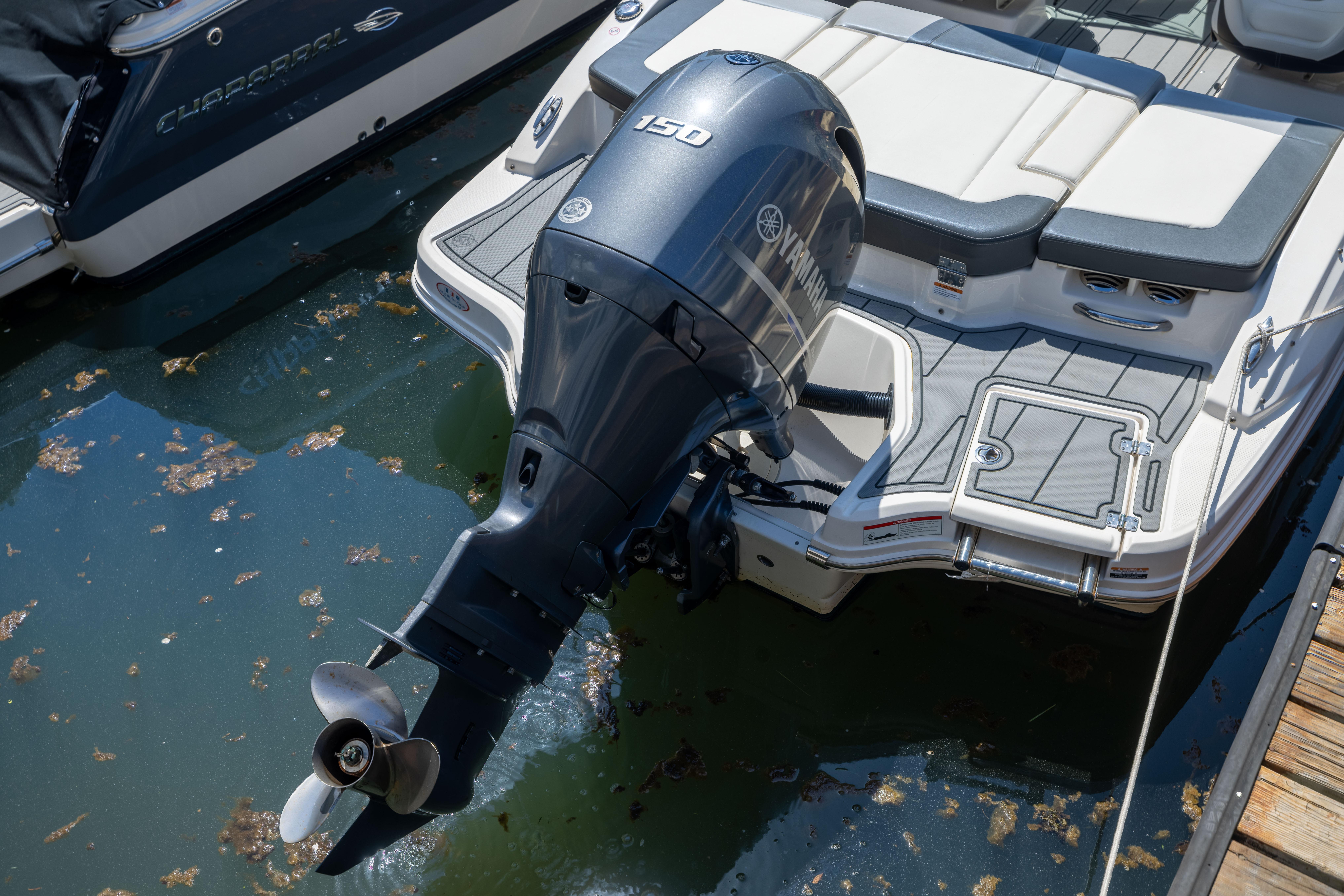 2022 Chaparral 21 SSi OB boat with Yamaha outboard motor docked in water.