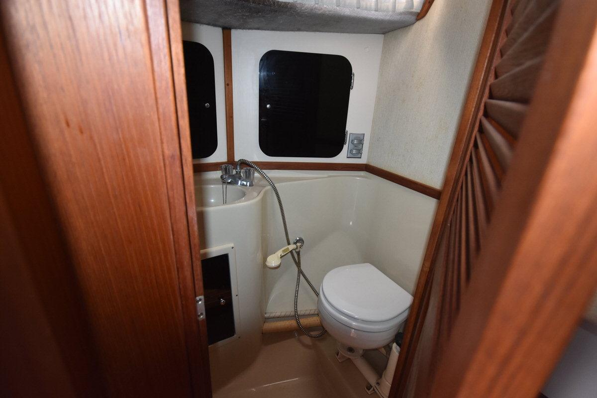 Interior view of a boat cabin with a toilet and sink.