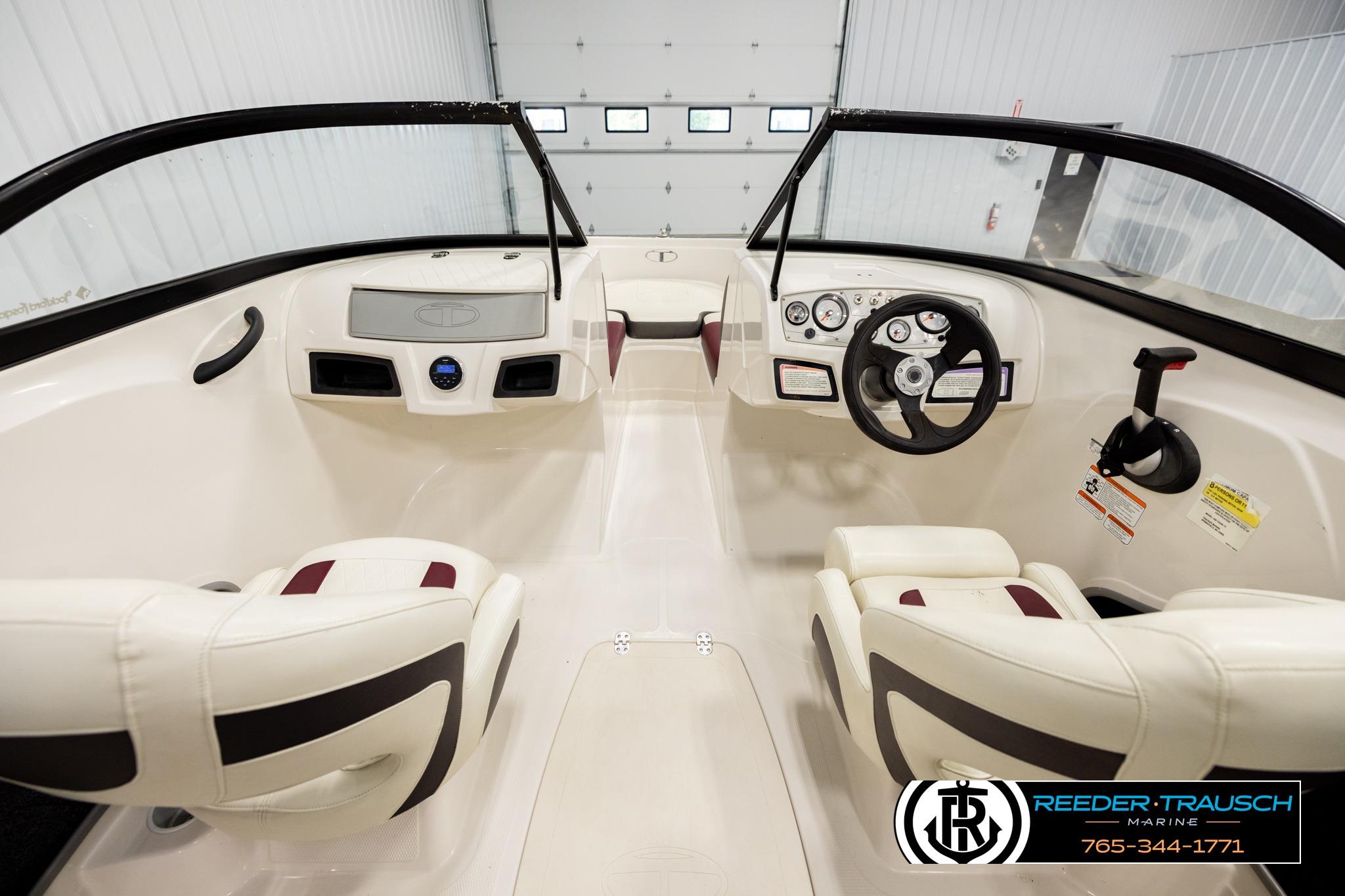 2016 Tahoe 450 TS boat interior with steering wheel and seating in a showroom.