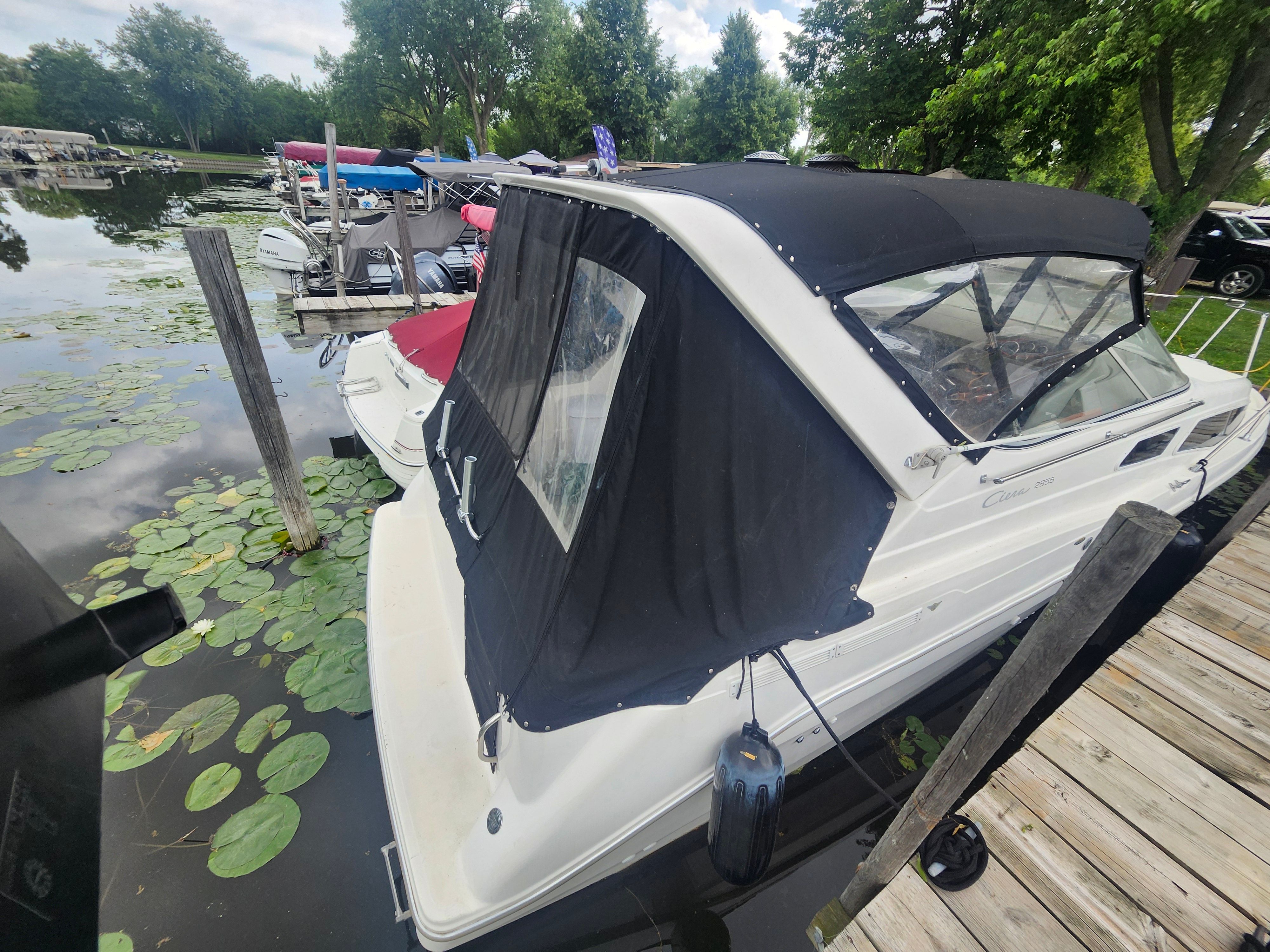 1998 Bayliner 2855 docked at a calm pier with lily pads.