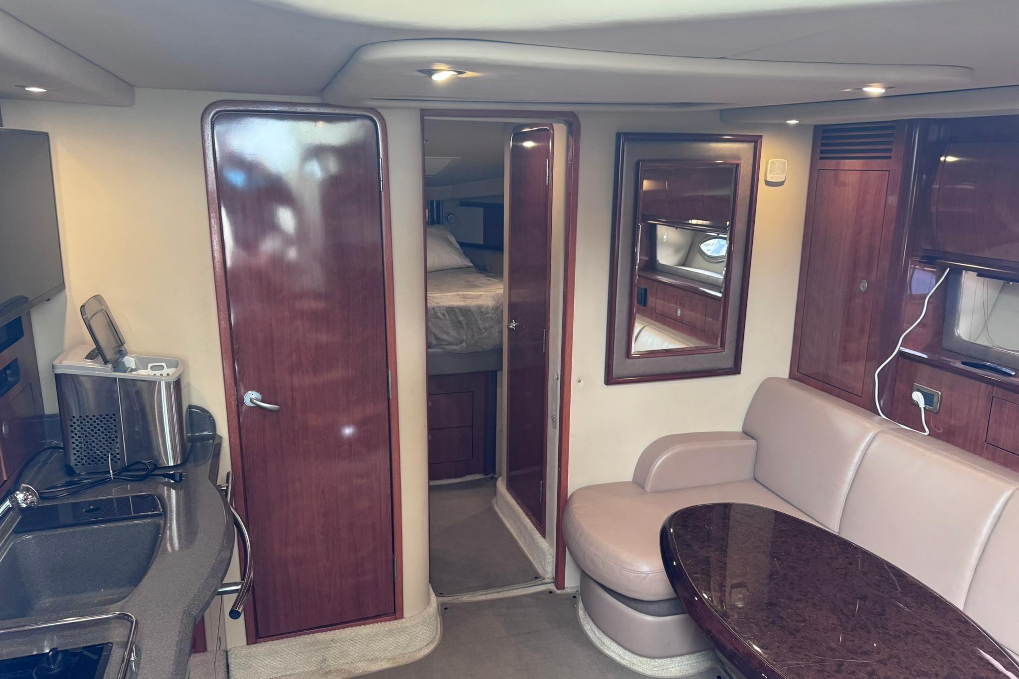 Interior of 2004 Sea Ray 390 Sundancer yacht with kitchenette, seating, and wood finishes.