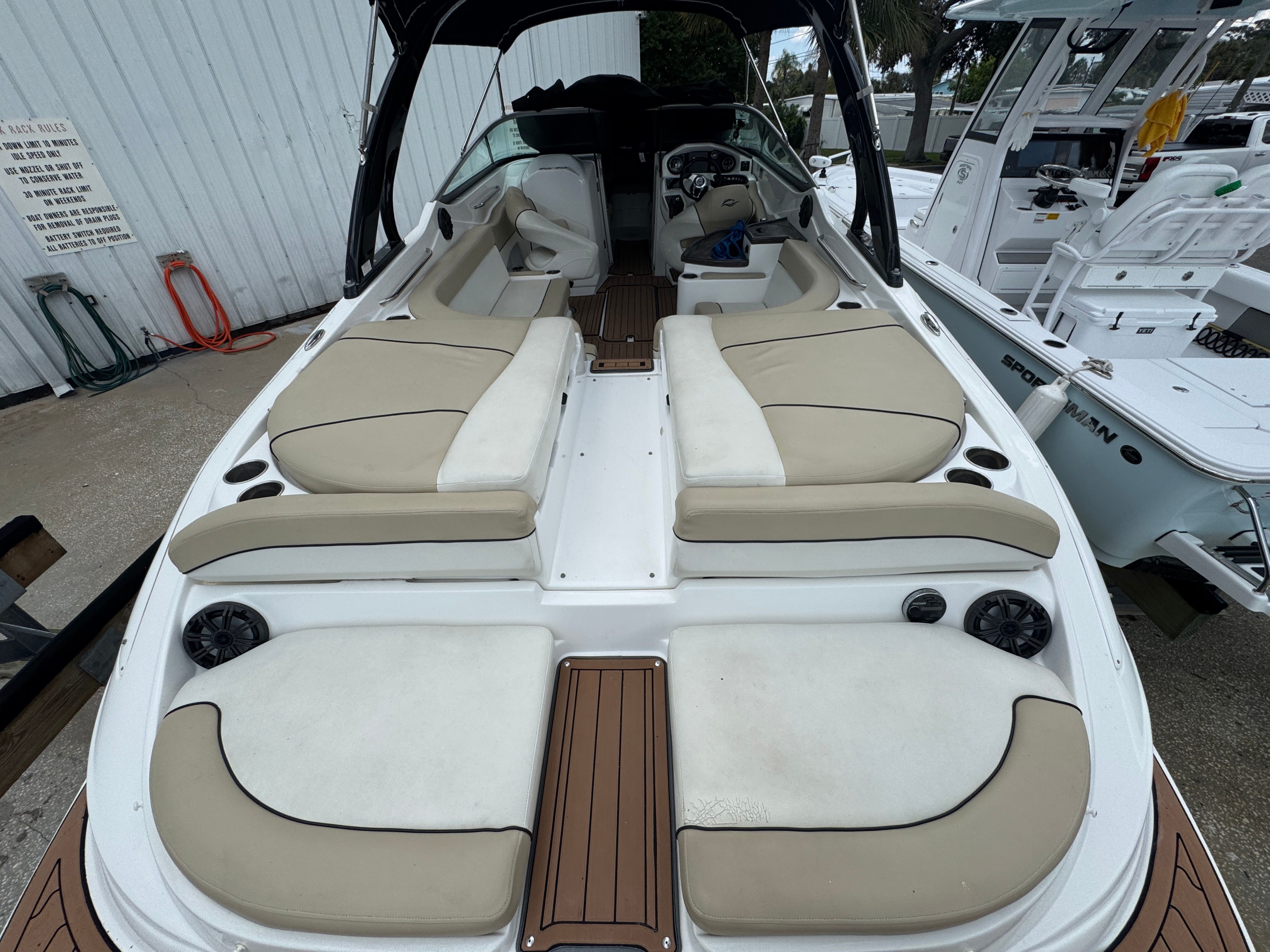Interior view of a 2017 Rinker QX29 BR boat with beige seating.