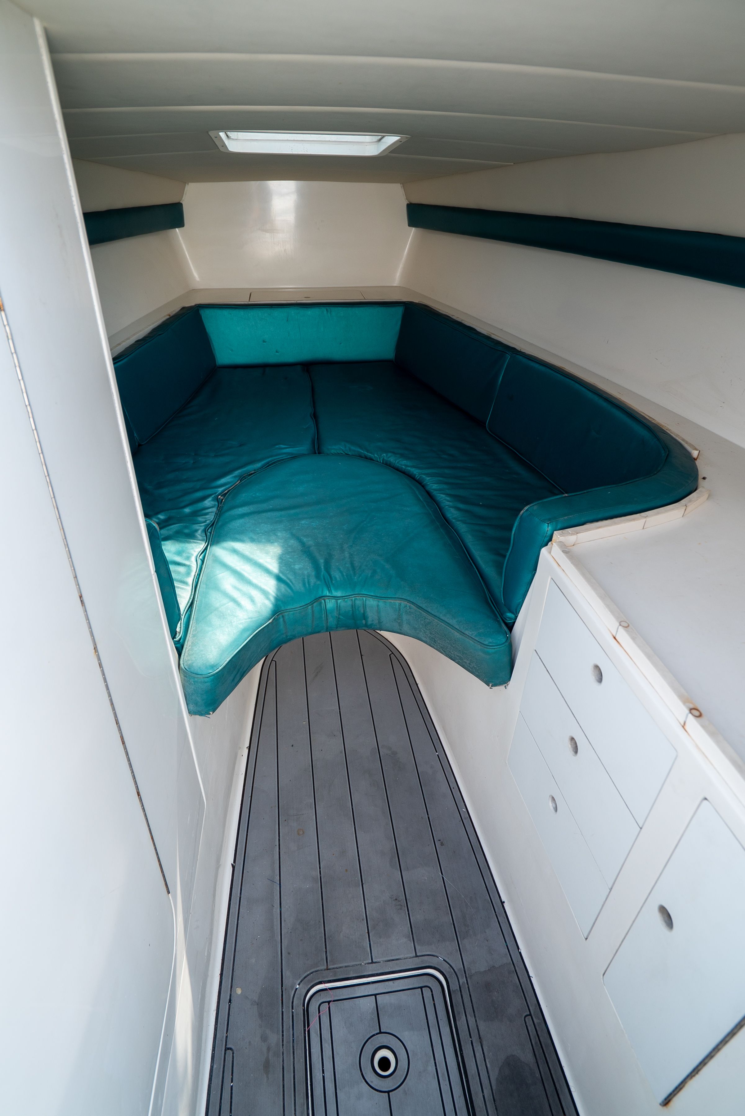 Cabin of the 2006 Tempest Offshore 40 with blue cushions and storage space.