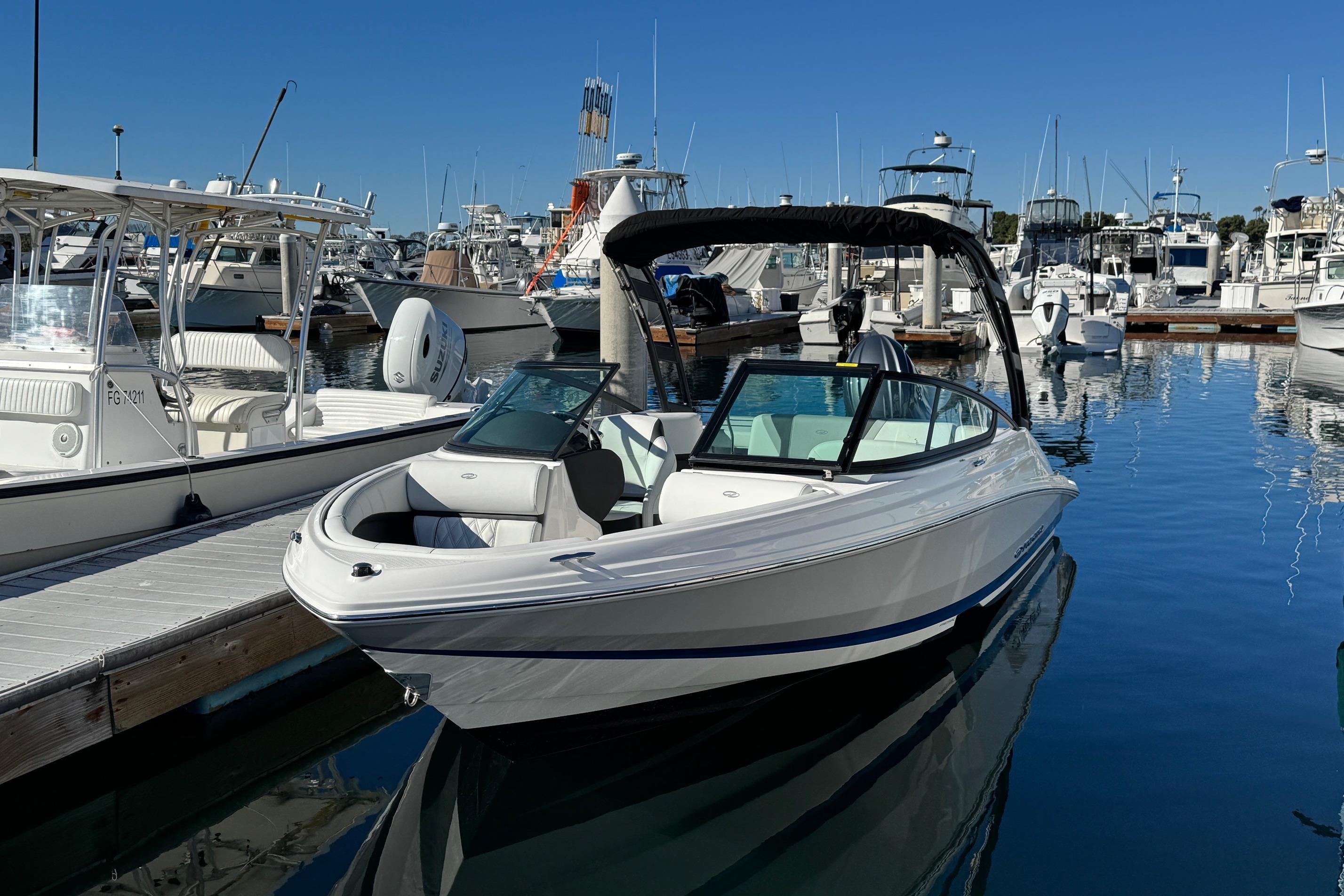 2026 Regal 21 OBX boat docked in a marina under clear blue skies.