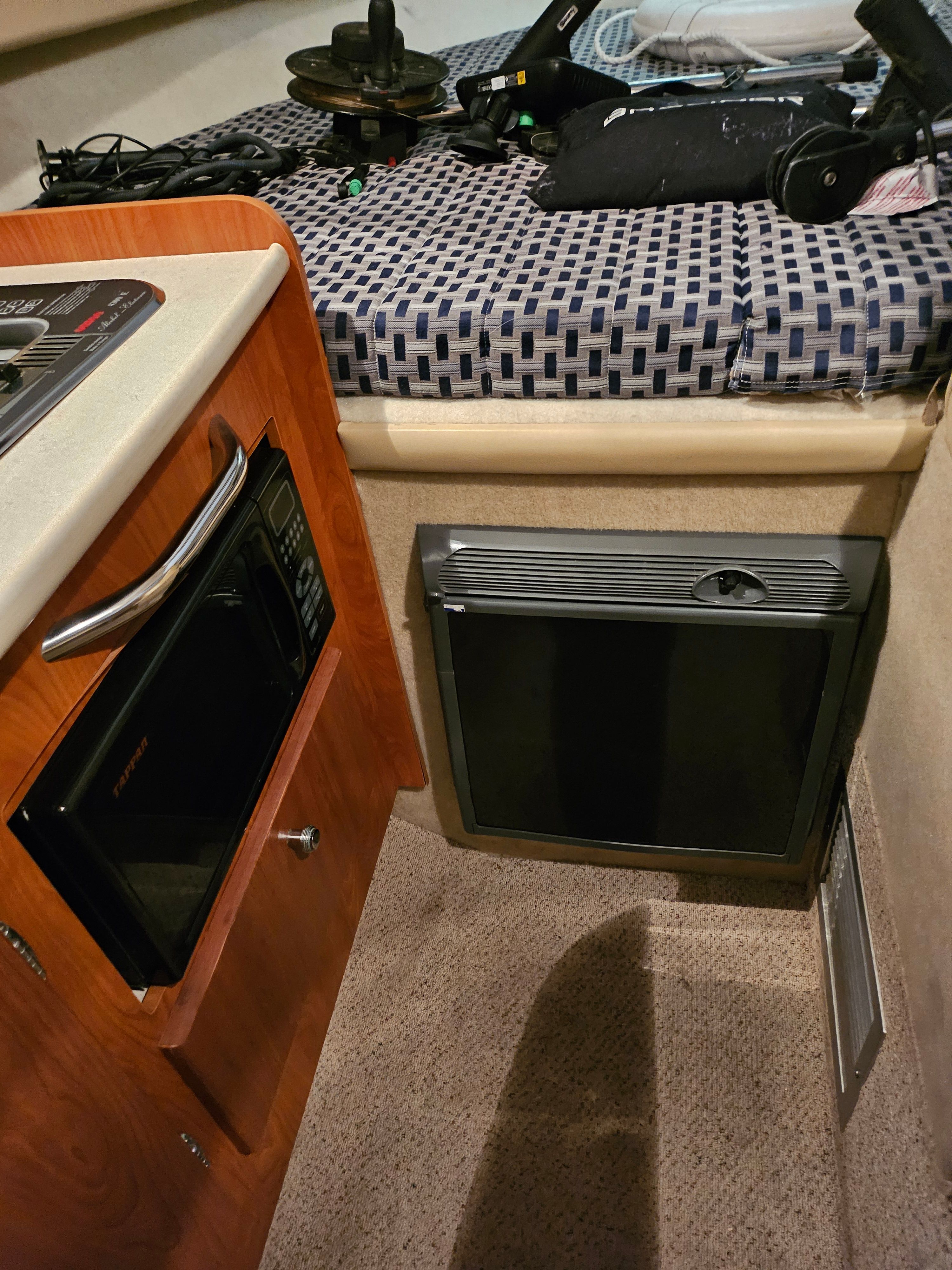 Interior of a 2005 Bayliner 242 Ceara with a microwave and refrigerator.