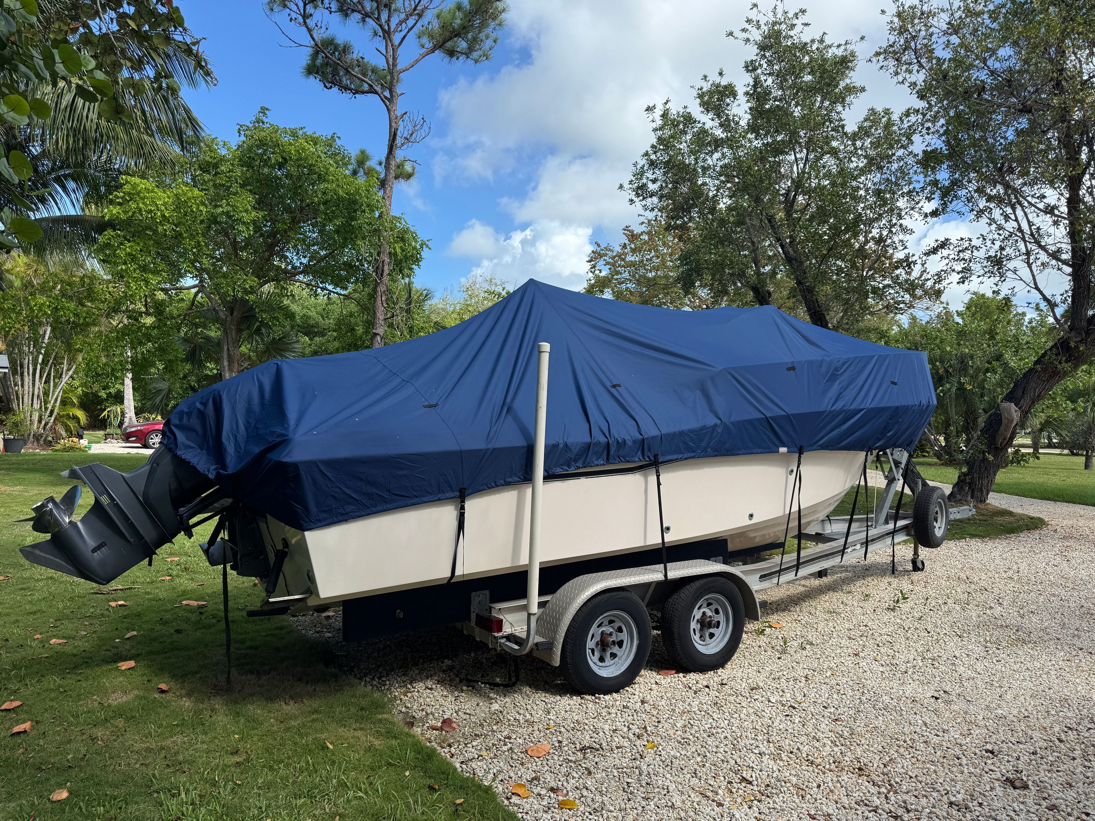 A 2005 Grady-White Seafarer 226 boat, covered and parked on a trailer outdoors.