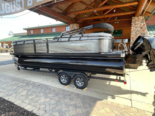 2024 Regency 230 DL3 pontoon boat on trailer, displayed outdoors.