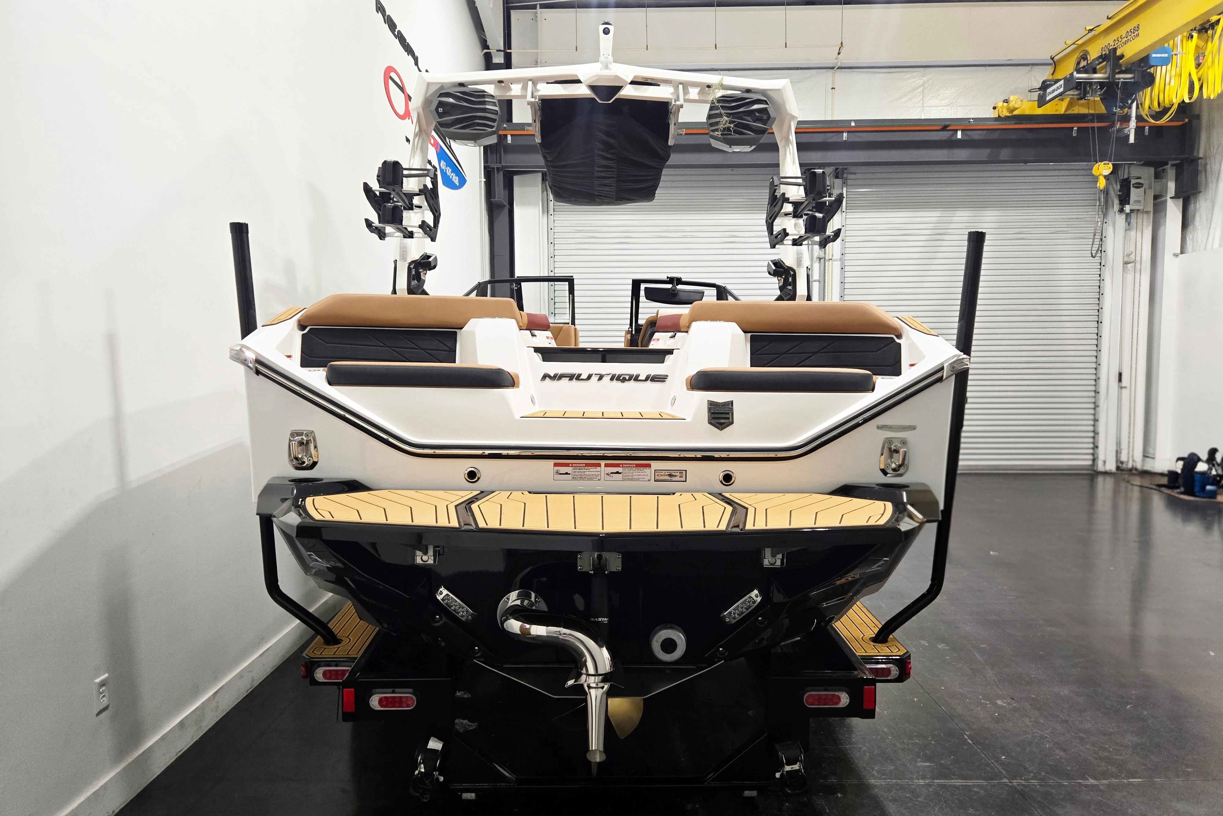 2026 Nautique Super Air Nautique S23 boat in a garage, rear view.
