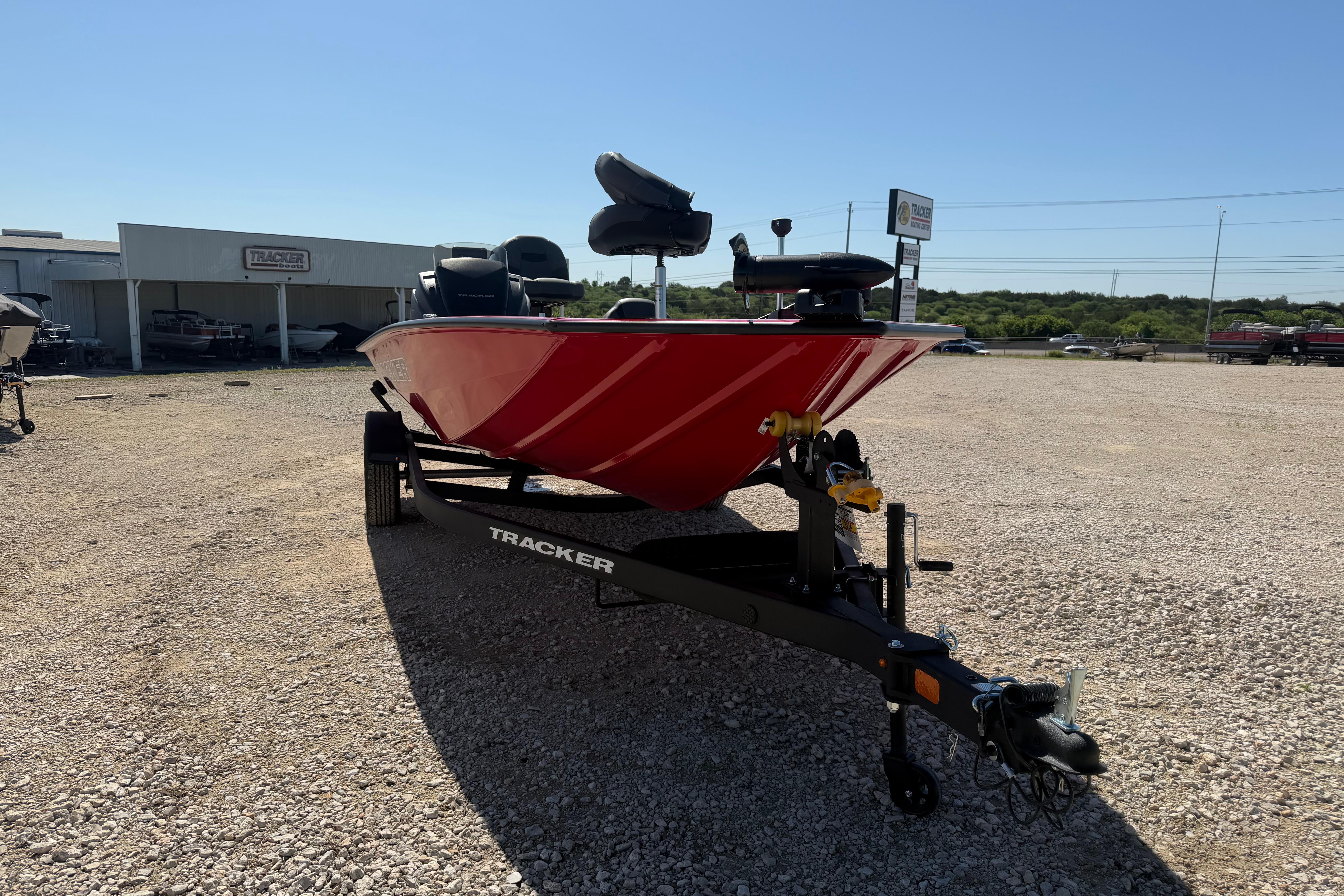 Red 2026 Tracker Pro Team 195 boat on trailer in outdoor dealership lot.