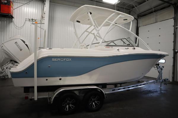2025 Sea Fox 228 Traveler boat in a garage, featuring a sleek blue and white design.