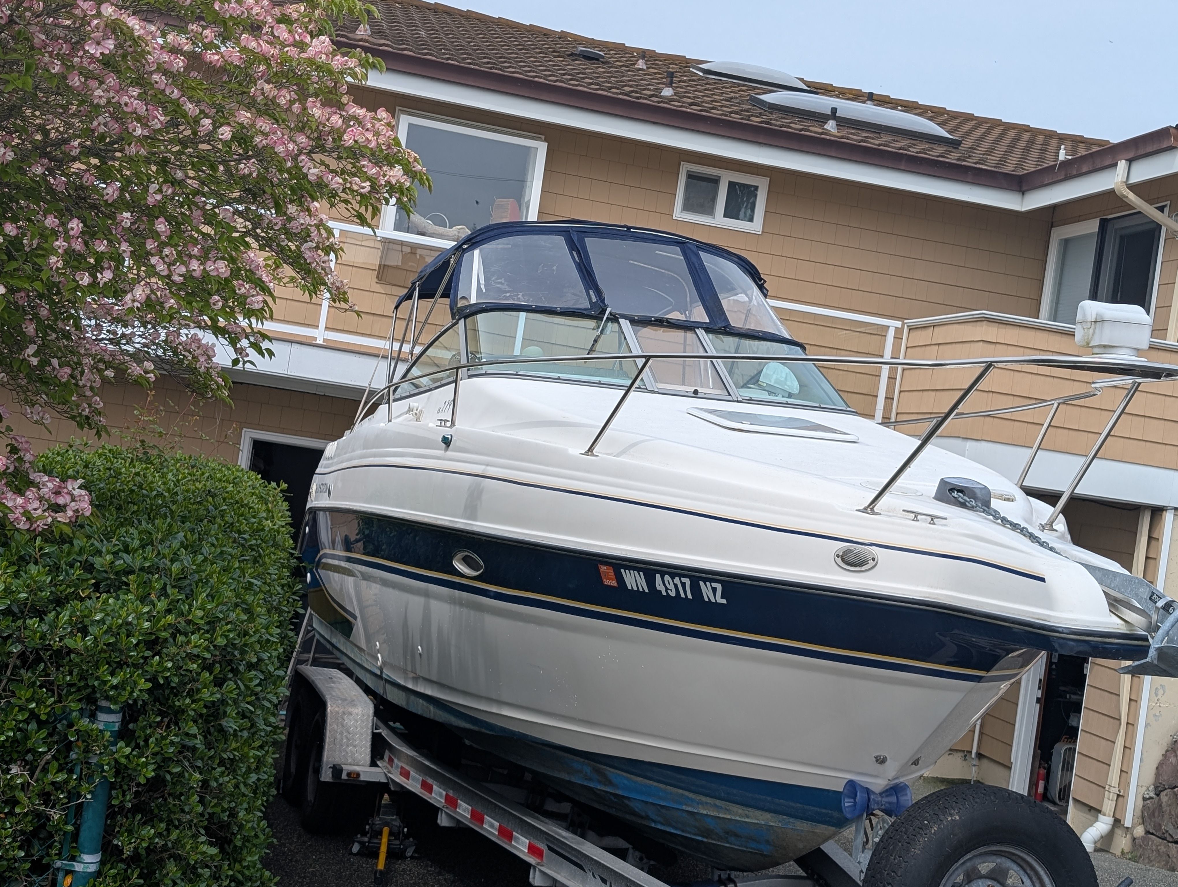 2006 Glastron GS boat on trailer parked in front of house.