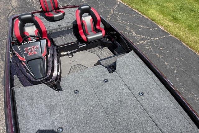 2026 Nitro Z21 XL Pro boat interior with red and black seats on a paved surface.