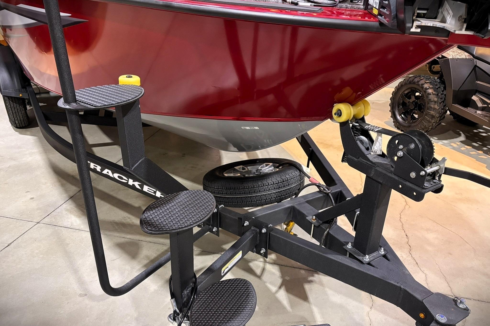 2025 Tracker Targa V-19 WT boat on trailer with steps, red hull, and winch system.
