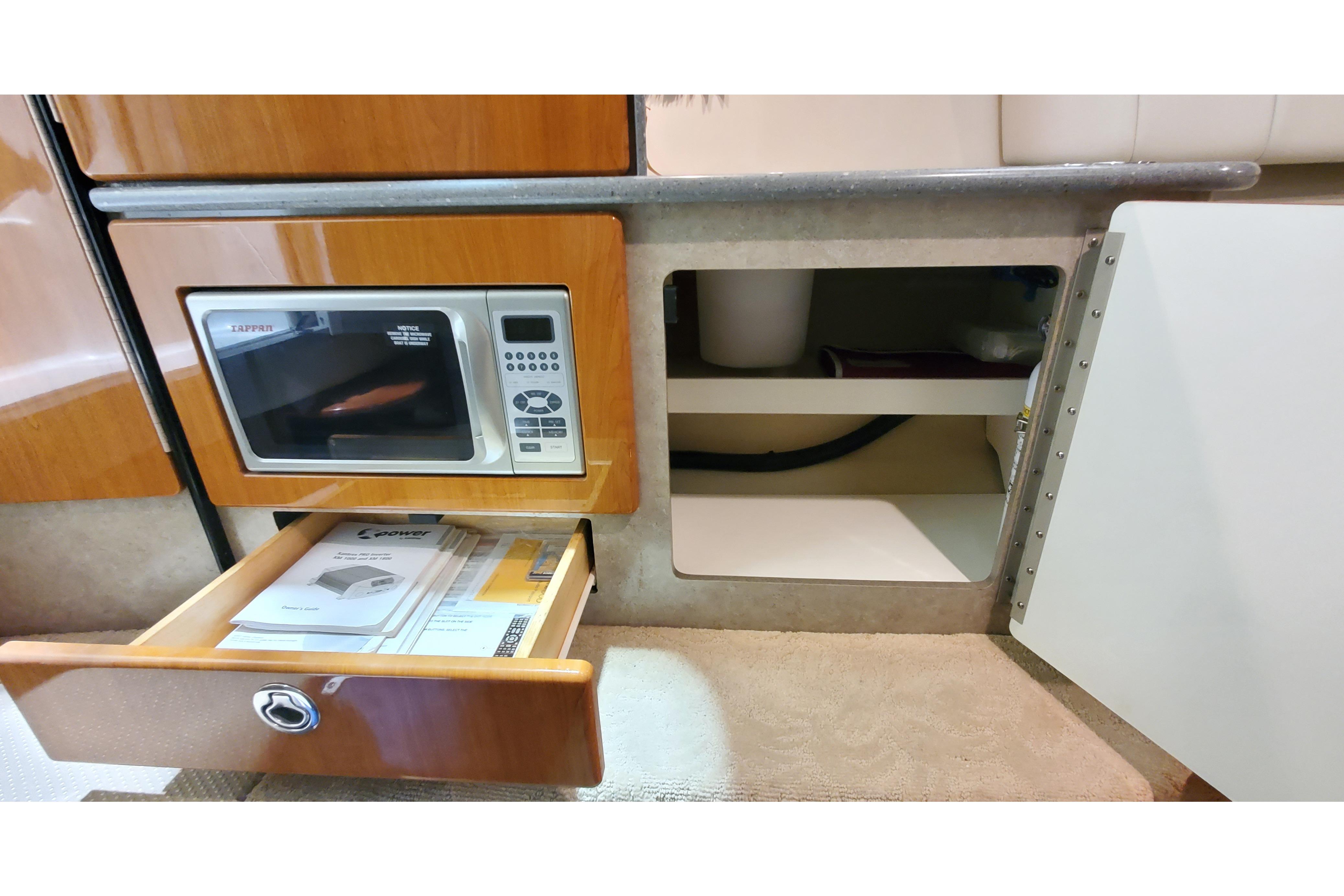 2006 Formula 330 Sun Sport interior with microwave, open drawer, and storage cabinet.