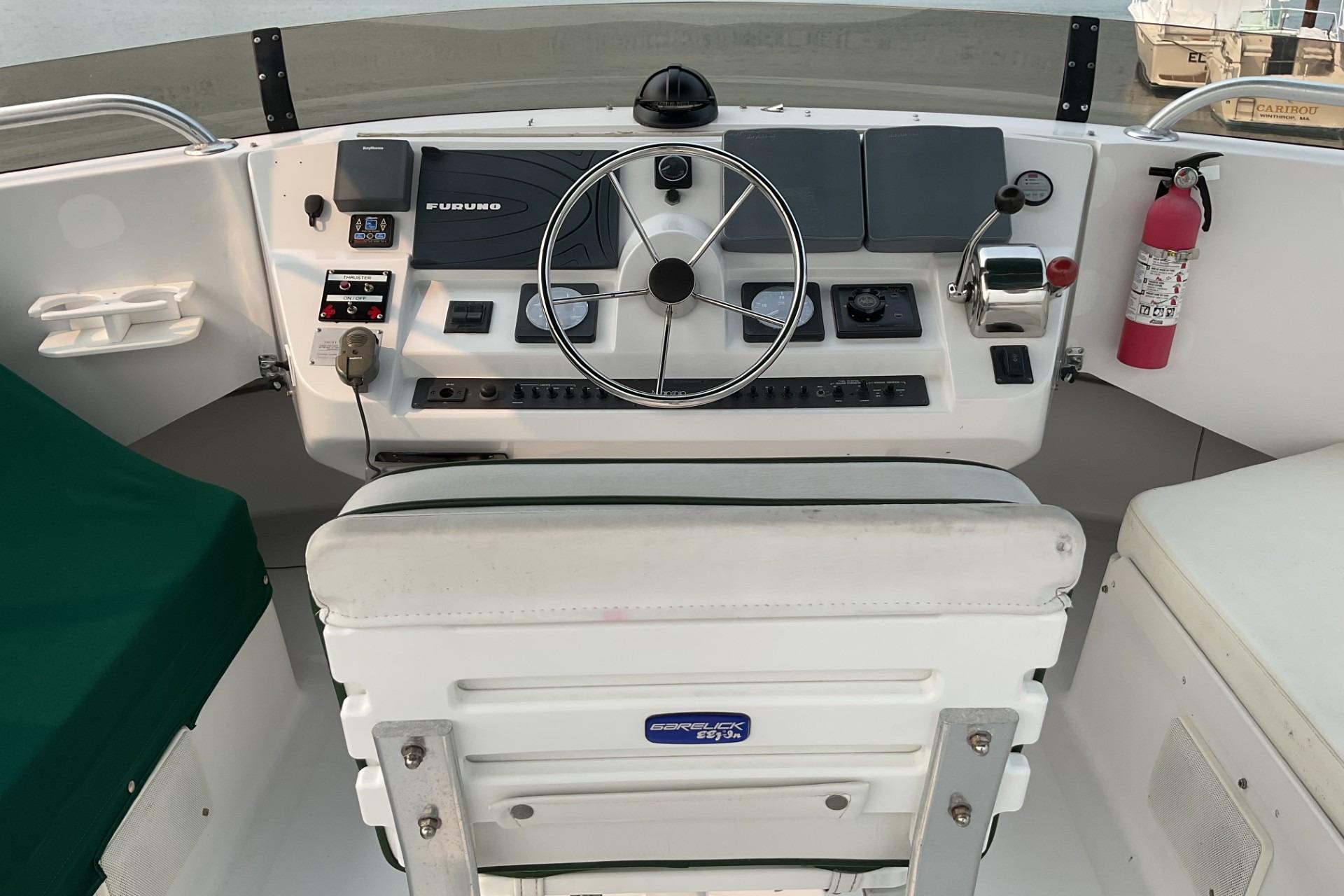 1999 Mainship 350 Trawler helm with steering wheel, controls, and navigation equipment.