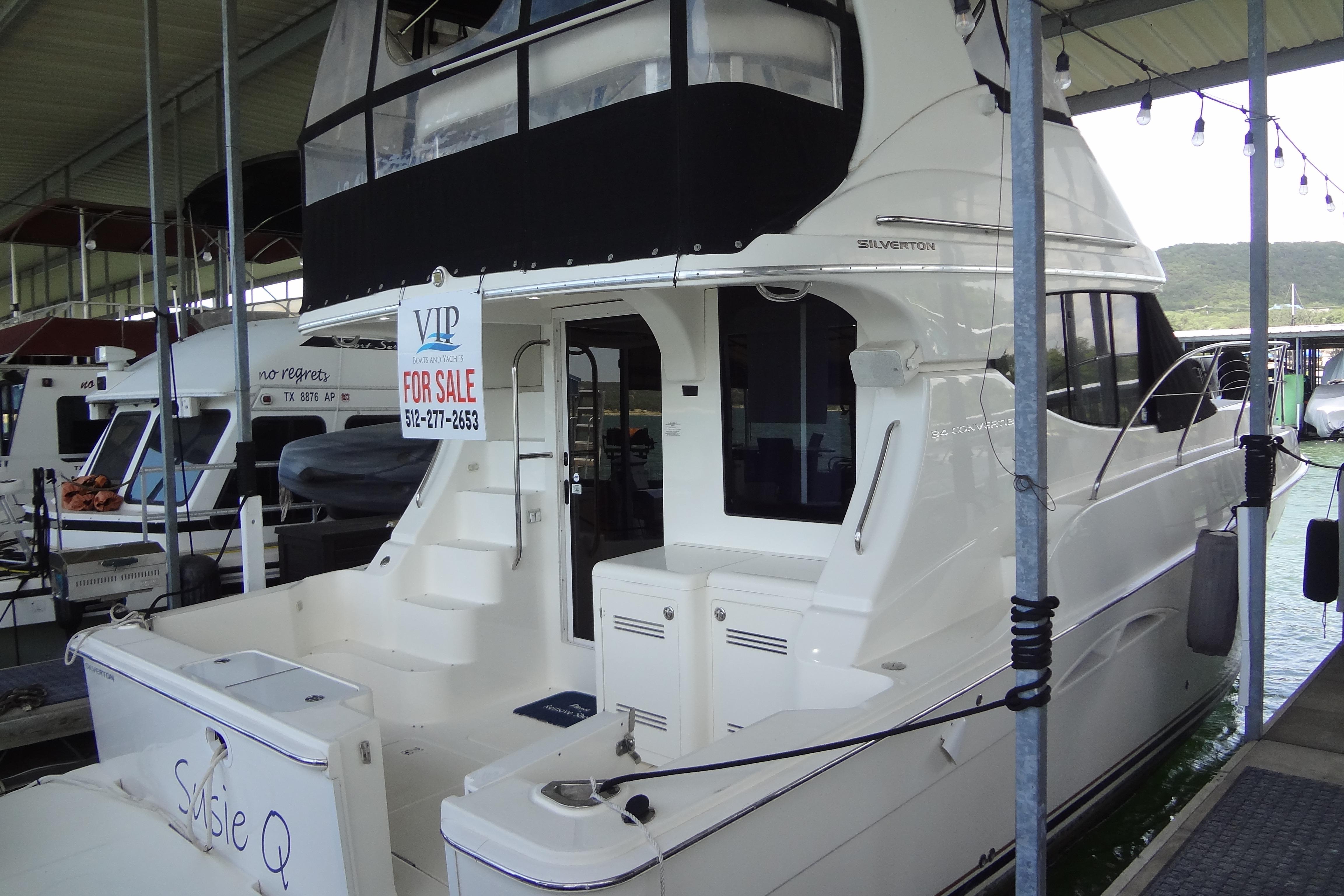 2005 Silverton 34 Convertible yacht for sale at marina dock.