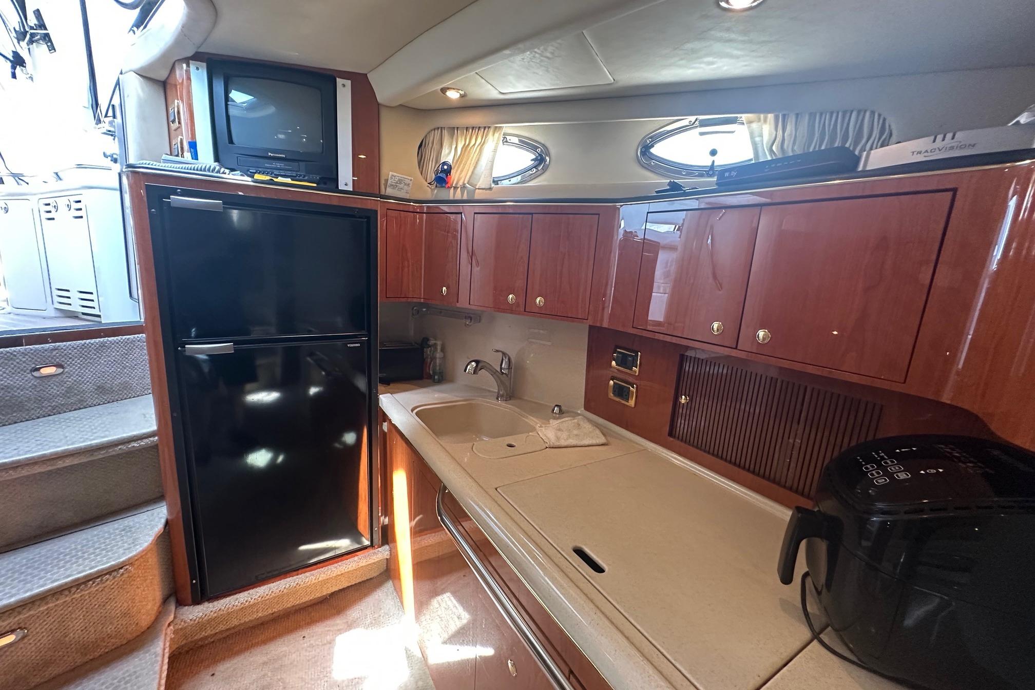 Interior of 2001 Sea Ray 410 Sundancer yacht with kitchenette and appliances.