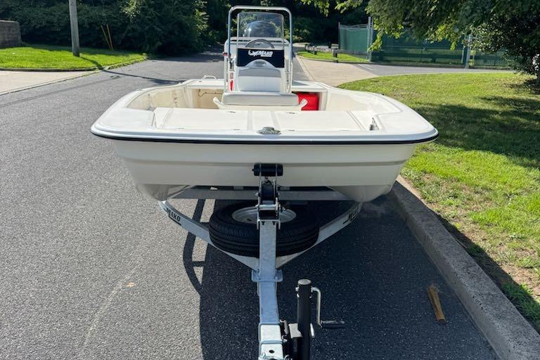 2026 Mako Pro Skiff 17 CC boat on trailer, parked on a sunny street.