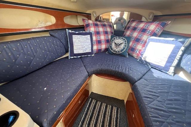 Interior of 2003 Sea Ray 260 Sundancer with blue quilted seating and decorative pillows.