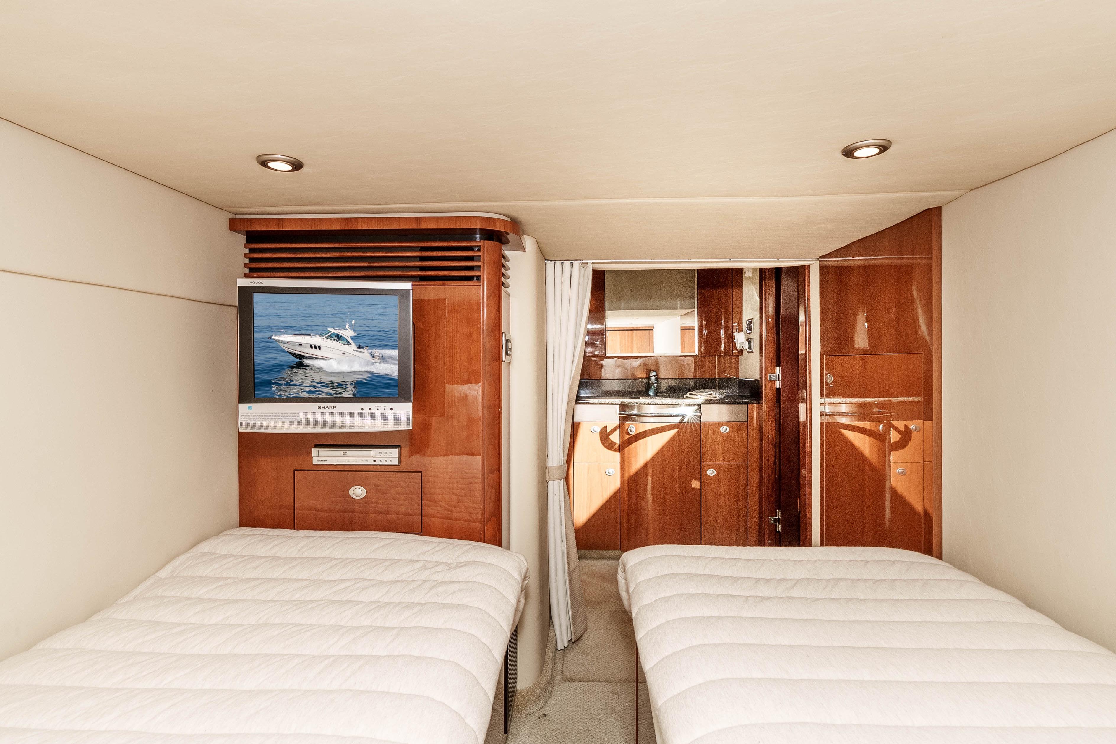 Interior of 2007 Sea Ray 48 Sundancer yacht with twin beds and TV.