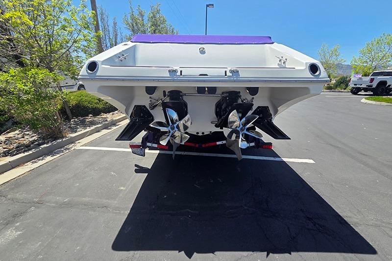 Rear view of a 2004 Fountain 38 Lightning boat with dual propellers in a parking lot.