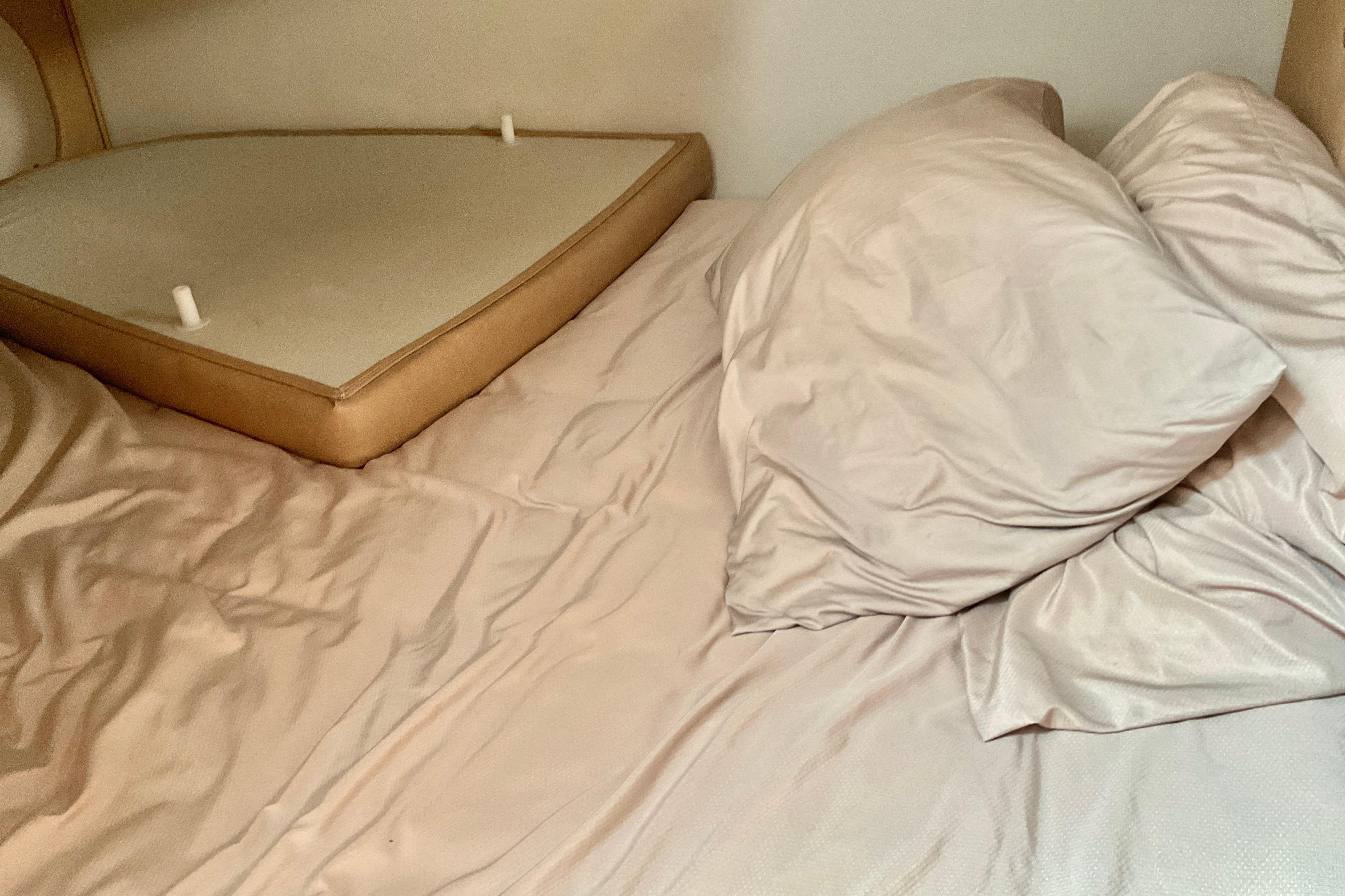 Interior cabin bed of 2013 Rinker 290 Express Cruiser with beige bedding.