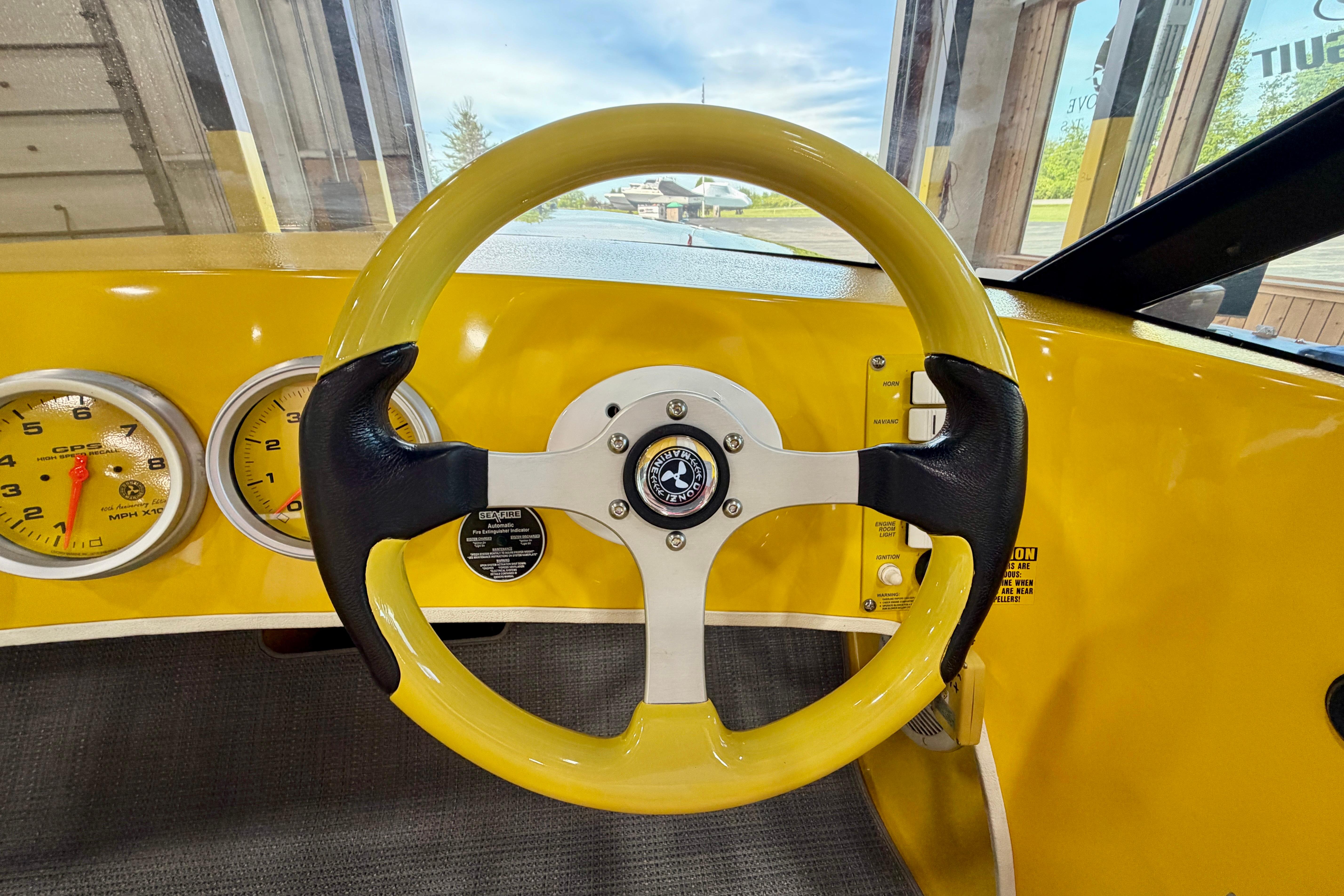 Yellow steering wheel and dashboard of a 2004 Donzi 22 Classic boat.