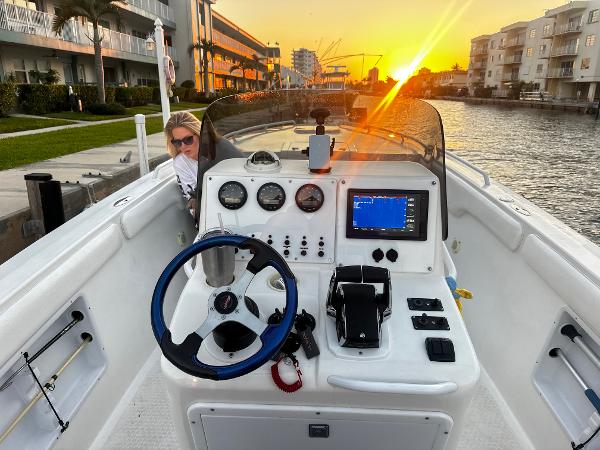 Concept 30 PF Sport 2001 boat at sunset, featuring a modern dashboard and canal view.