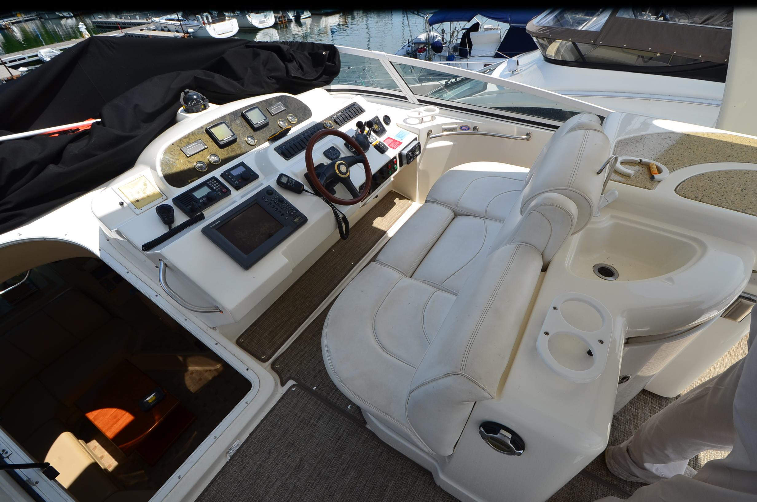 2003 Cruisers Yachts 5000 Sedan Sport helm with leather seating and navigation controls.