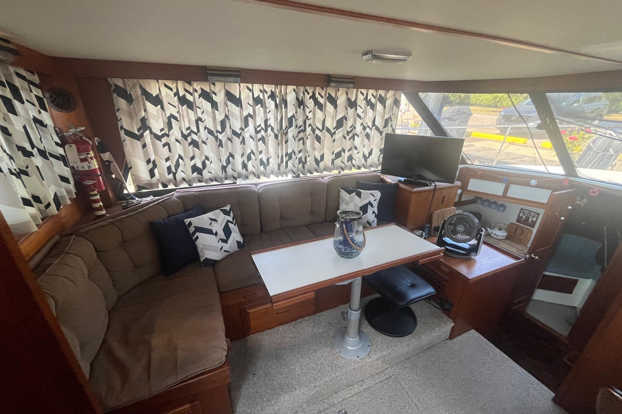 Cozy interior of 1990 Cooper Prowler 35 boat with seating, table, and decor.