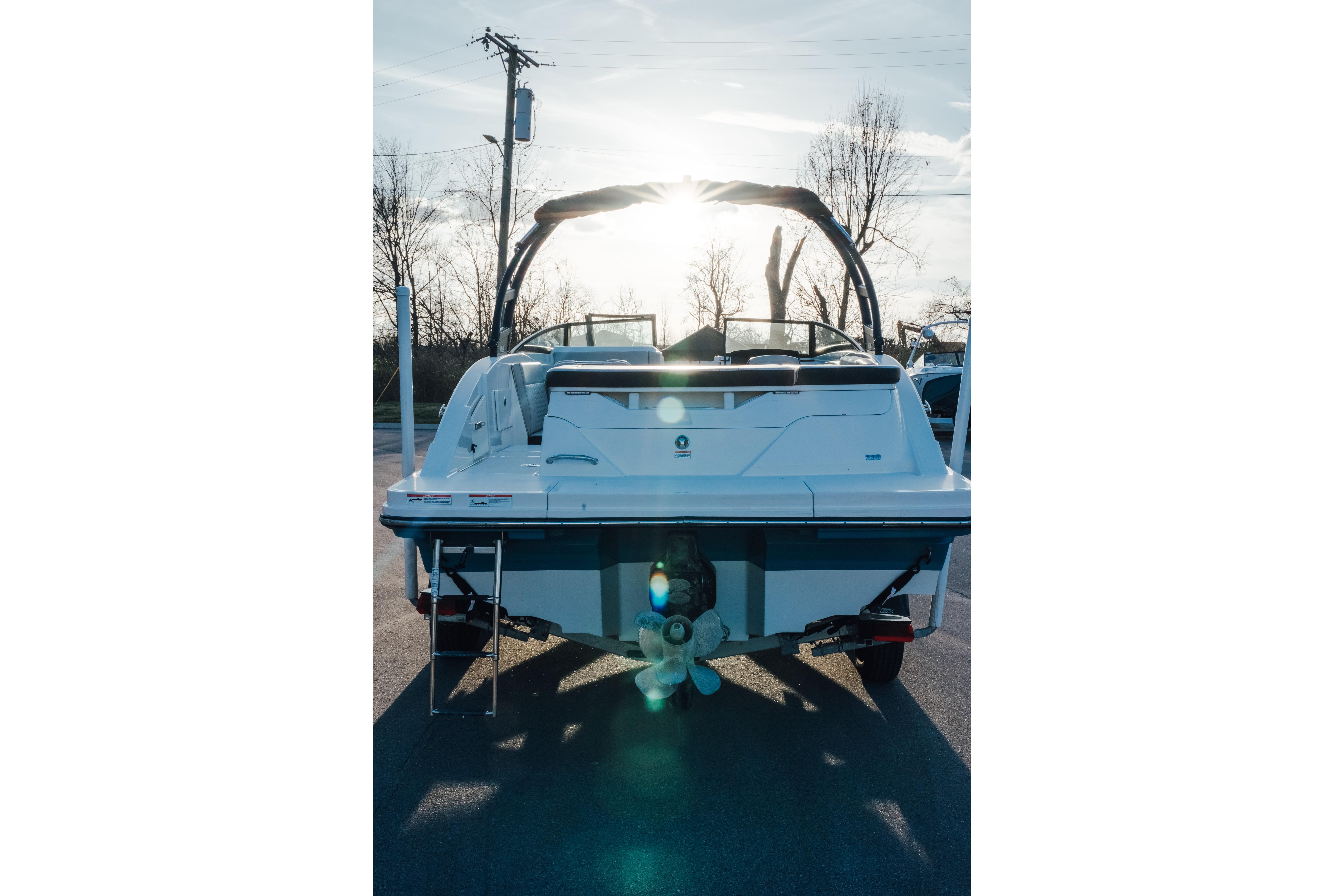 2023 Sea Ray SPX 230 boat rear view with sunlit background.
