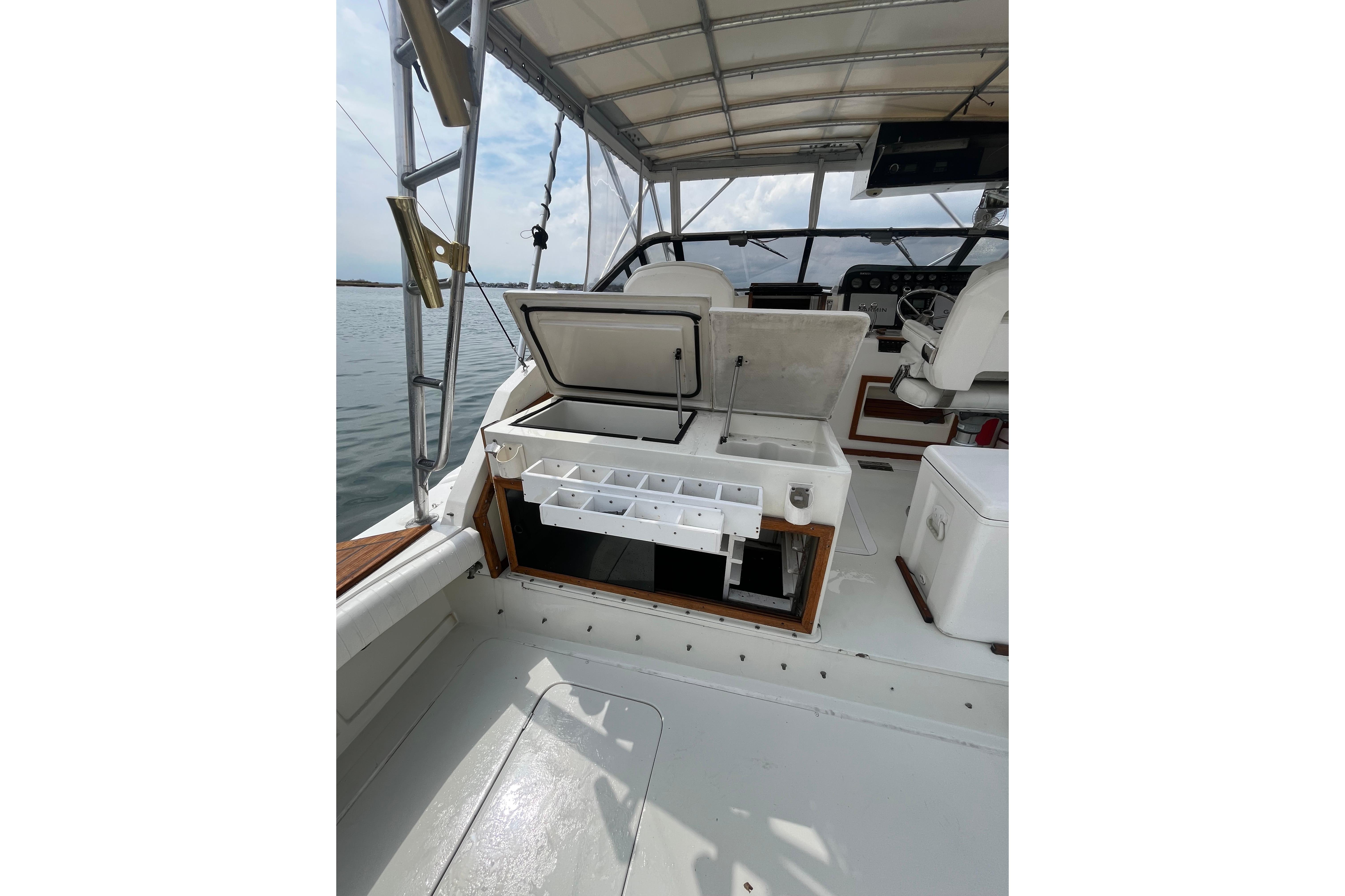 1989 Blackfin 31 Combi boat interior with open storage compartments and helm view.