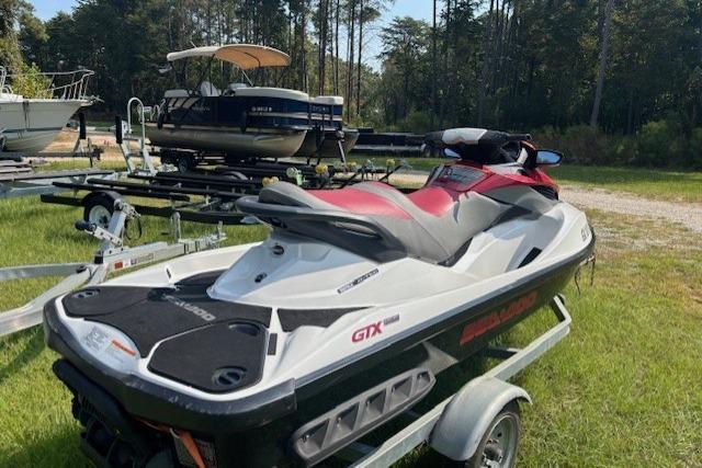 2010 Sea-Doo GTX 155 jet ski on trailer, parked outdoors near other boats.