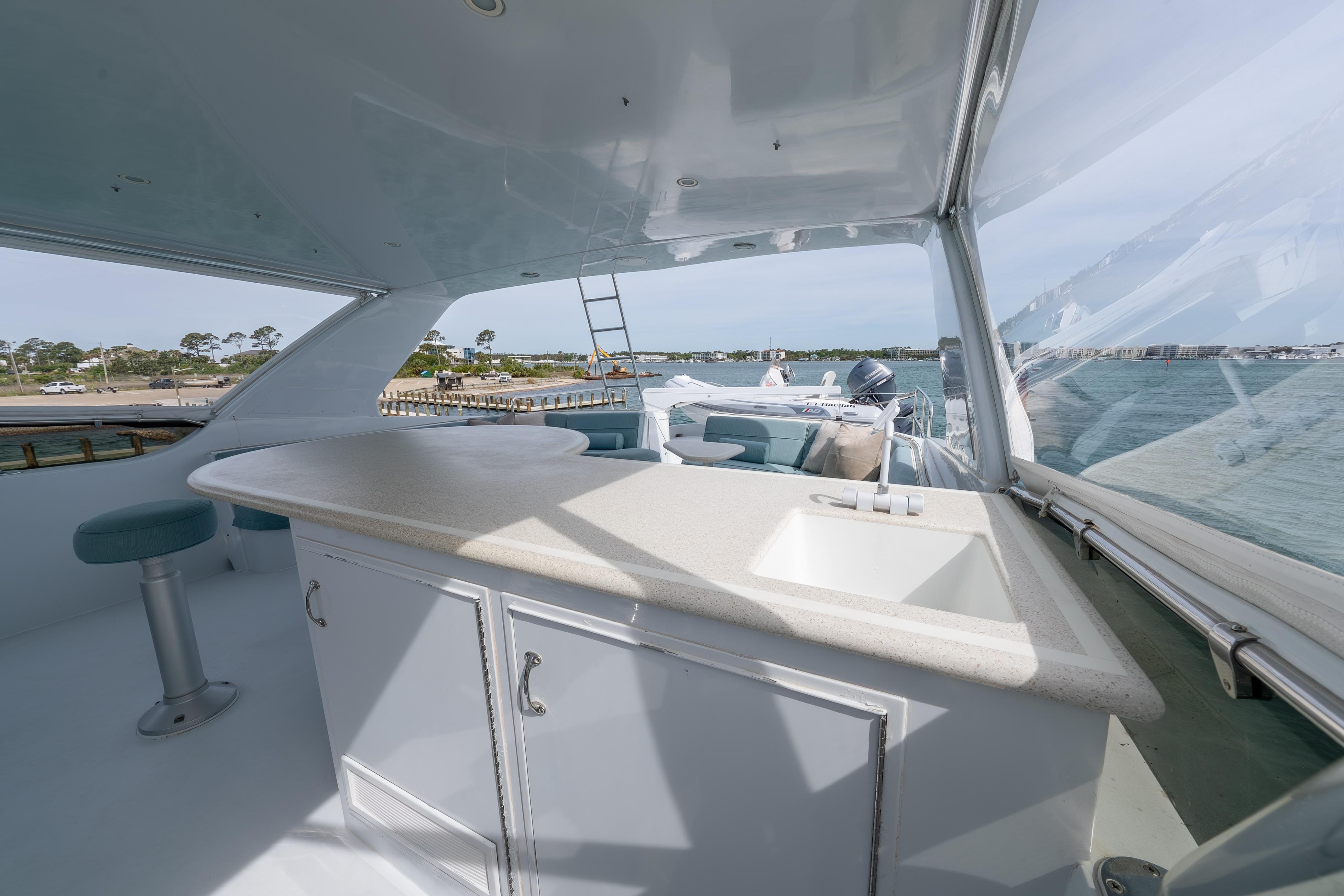 2004 Hatteras 75 Sport Deck Motor Yacht interior with bar and sink, overlooking water.